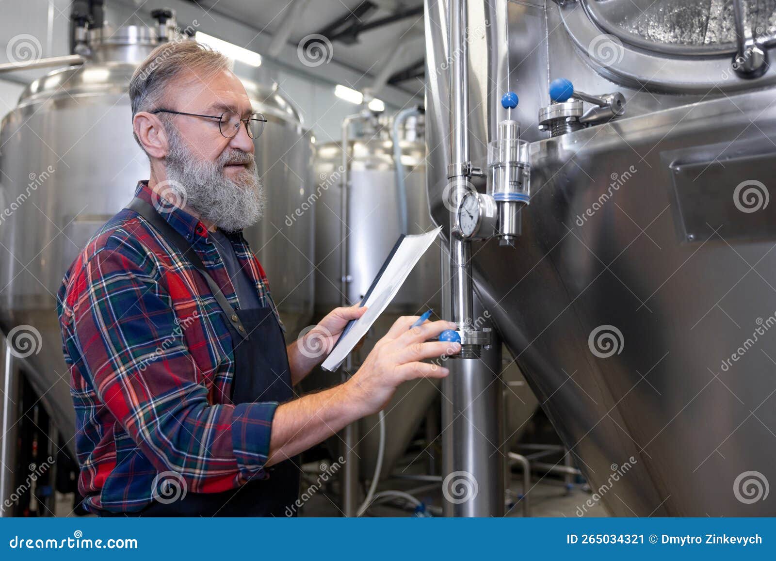 Brewery Worker Checking the Pressure in Tanks with Beer Stock Image