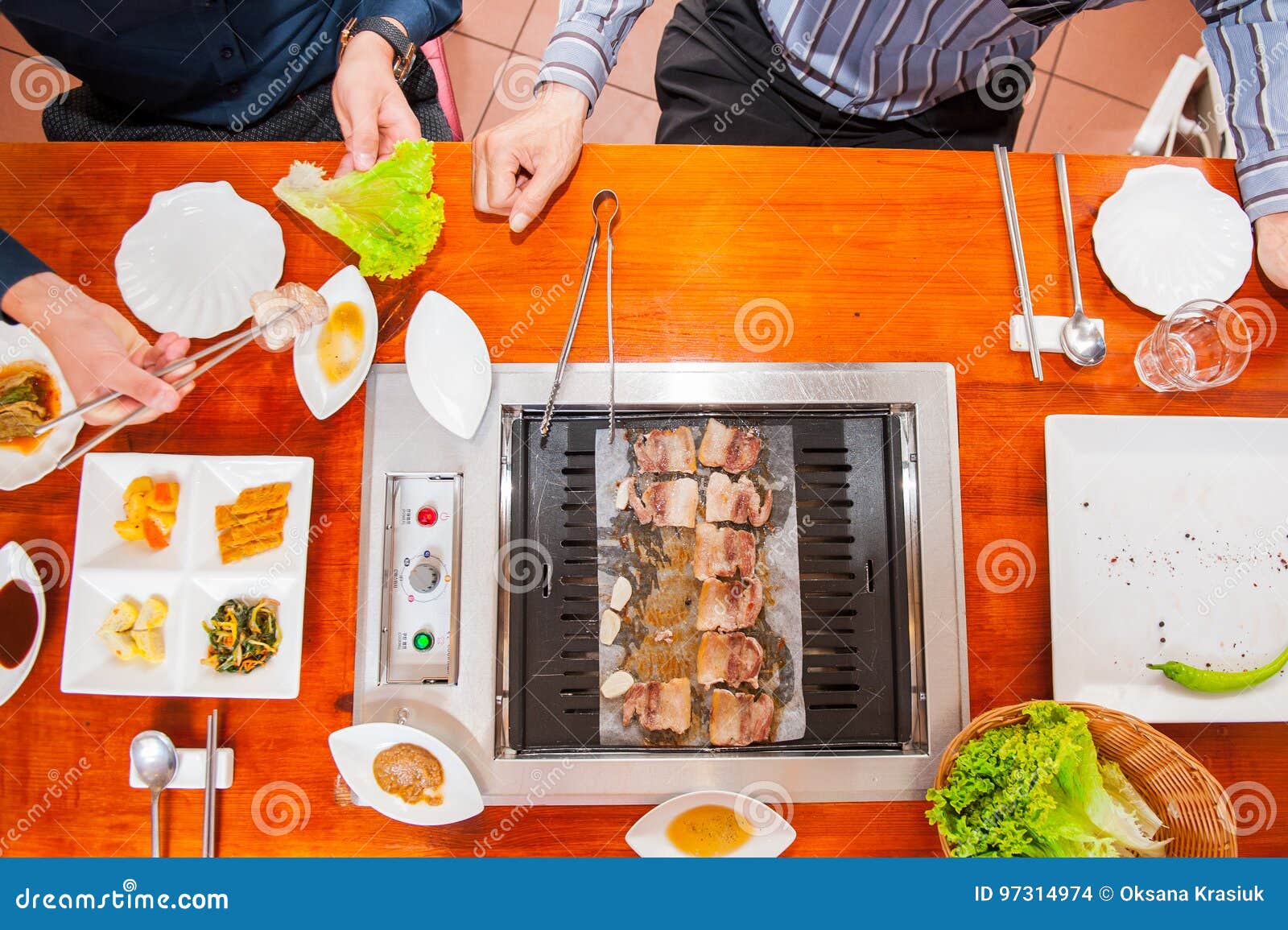 Process of Cooking Korean Barbecue Raw Pork on the Tabletop Grill in