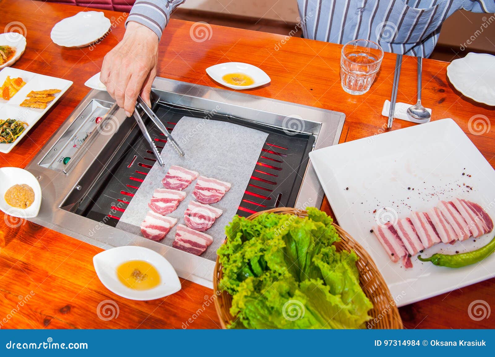 Process of Cooking Korean Barbecue Raw Pork on the Tabletop Grill in