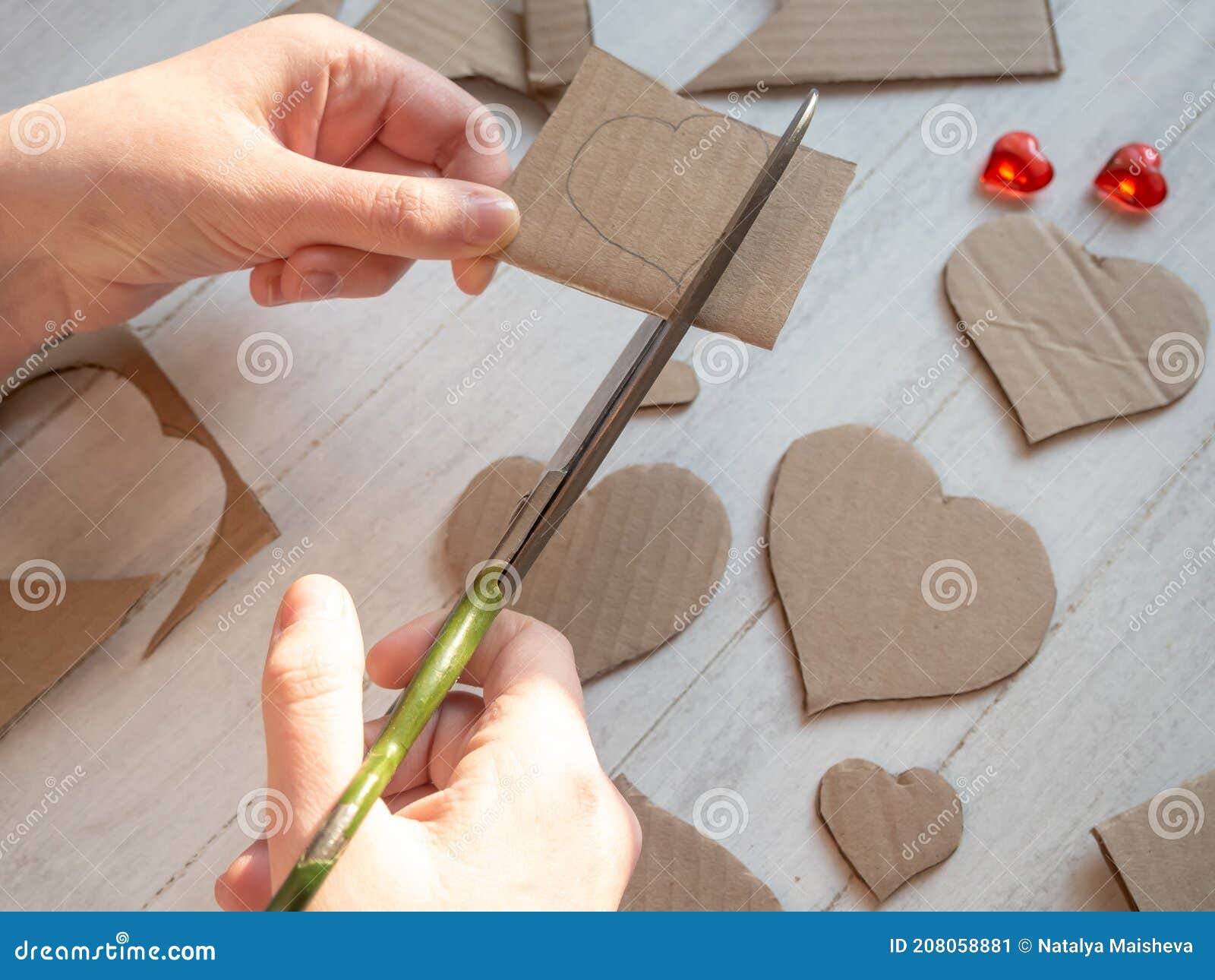 the process of cutting out hearts with scissors from cardboard. the concept of ecology, we use materials that are at hand. save