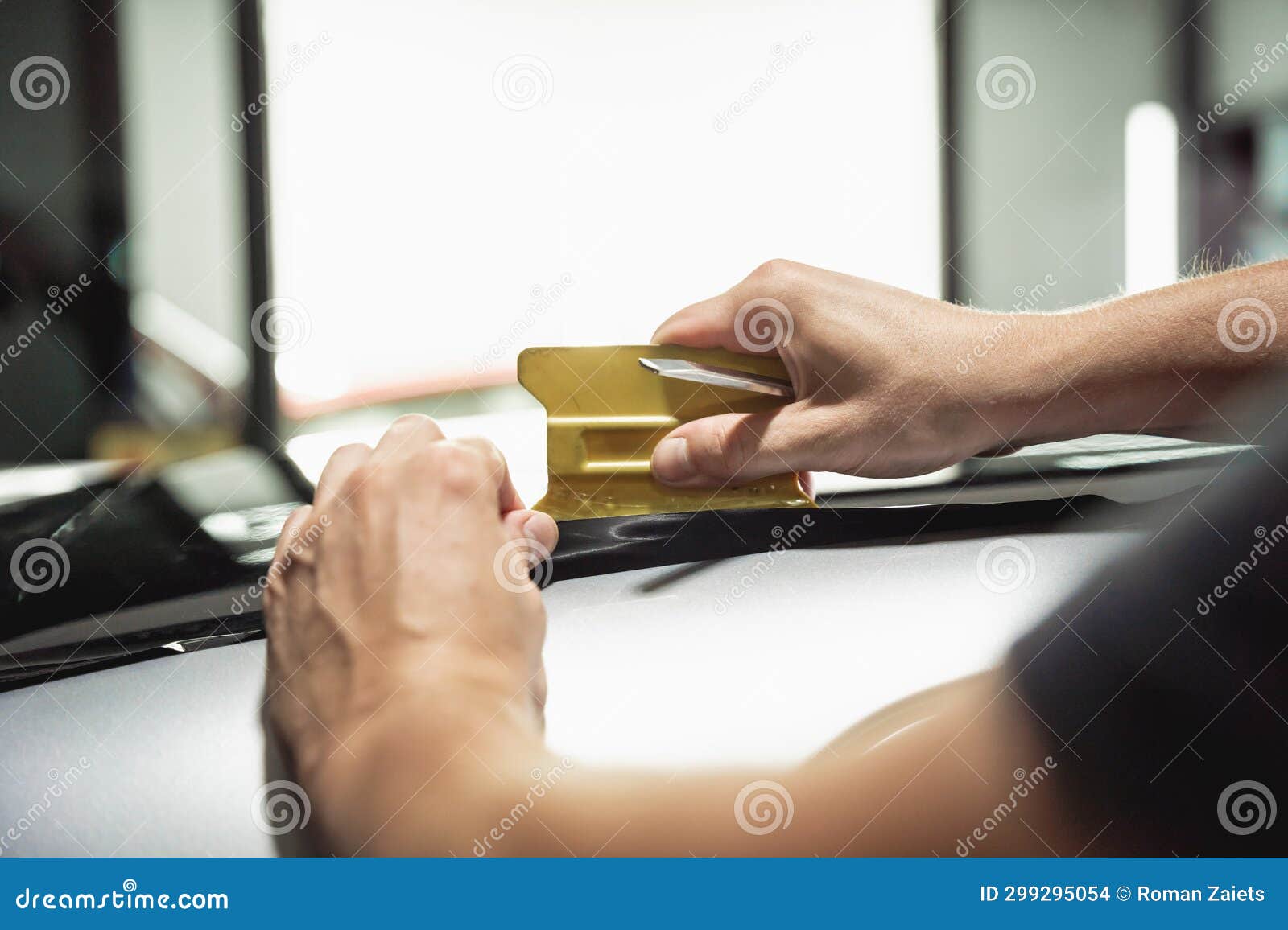 The Process of Installing Protective Film on the New Car. Stock Photo