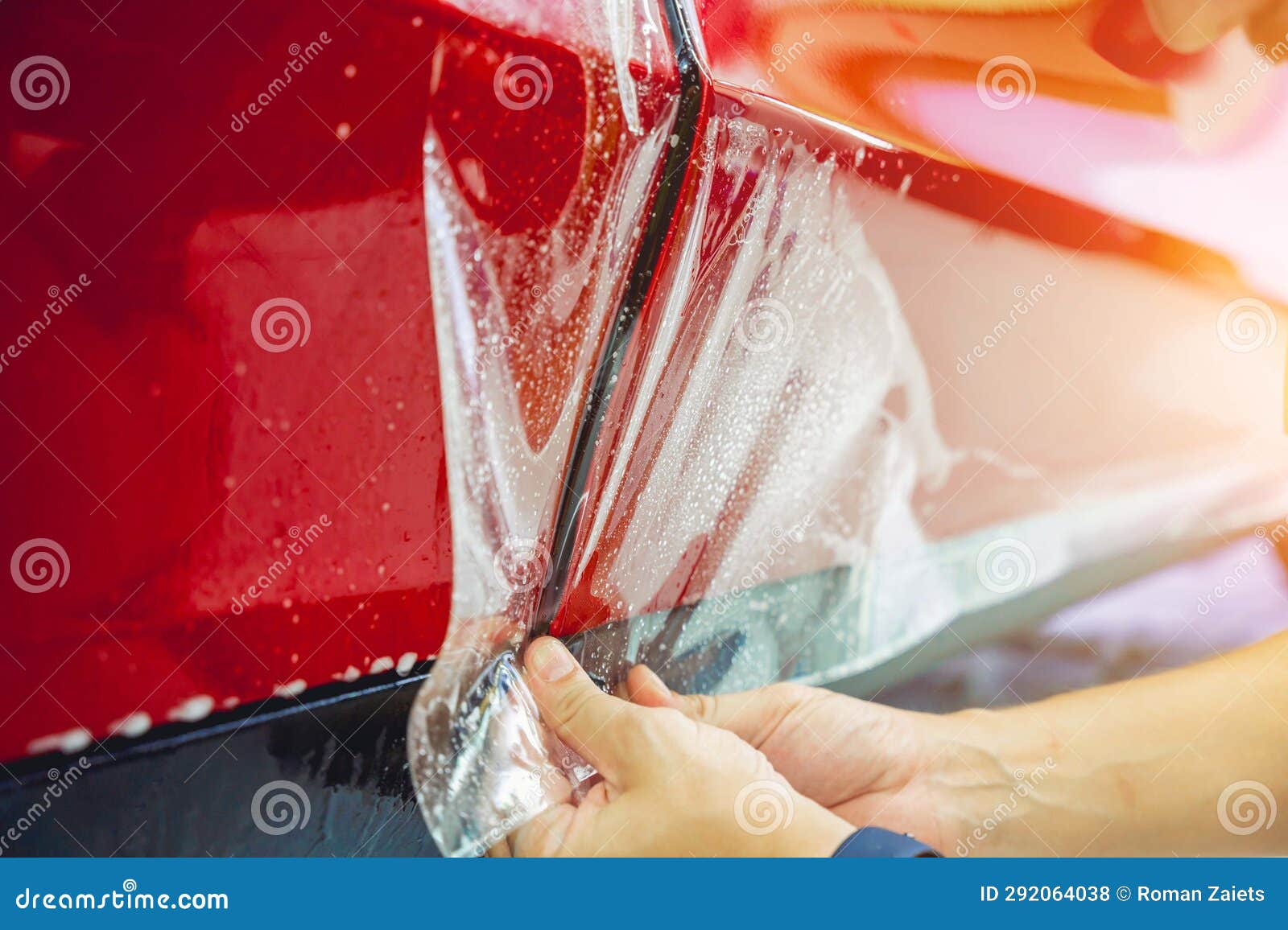The Process of Installing Protective Film on the New Red Car. Stock
