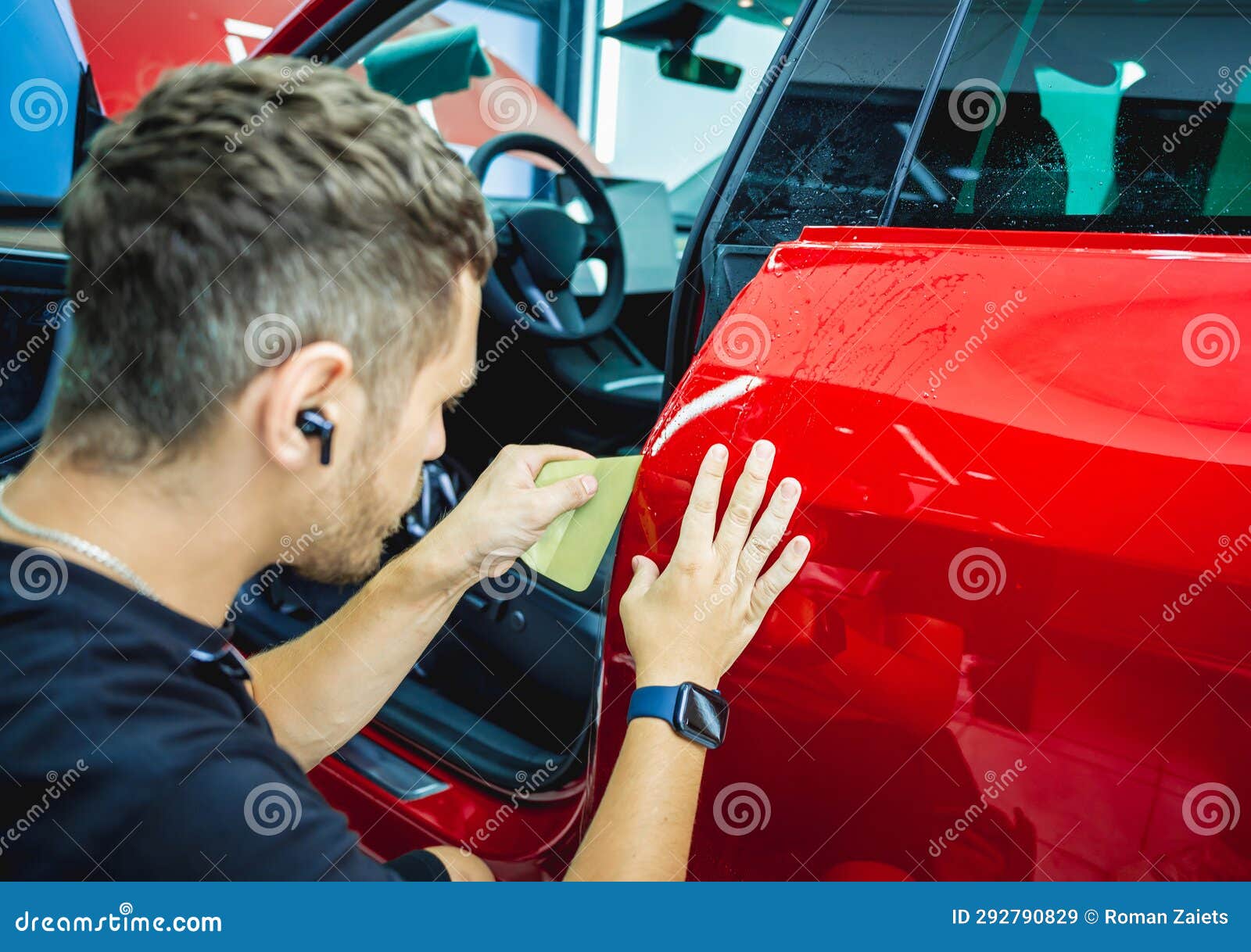 The Process of Installing Protective Film on the New Red Car. Stock
