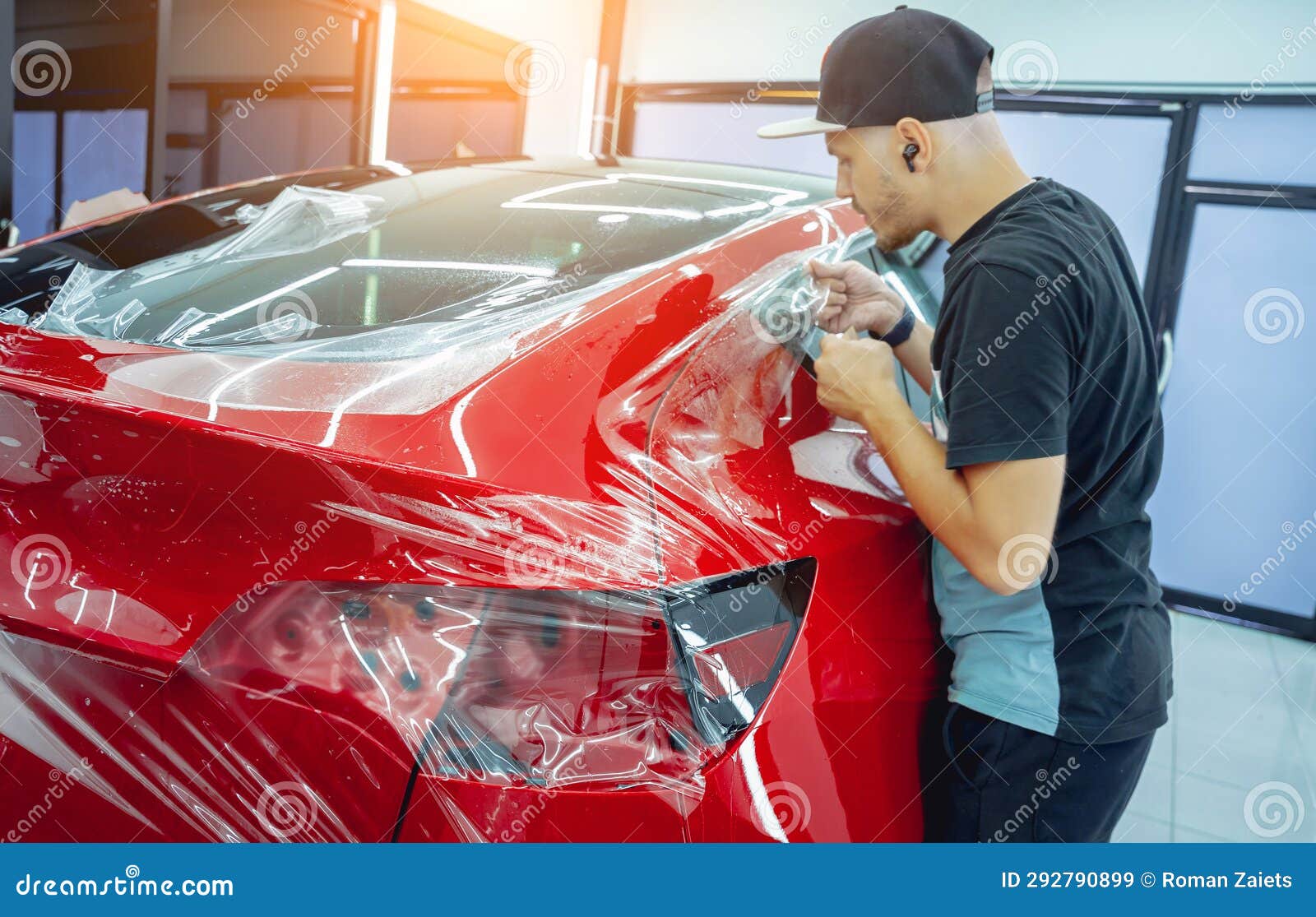 The Process of Installing Protective Film on the New Red Car. Stock