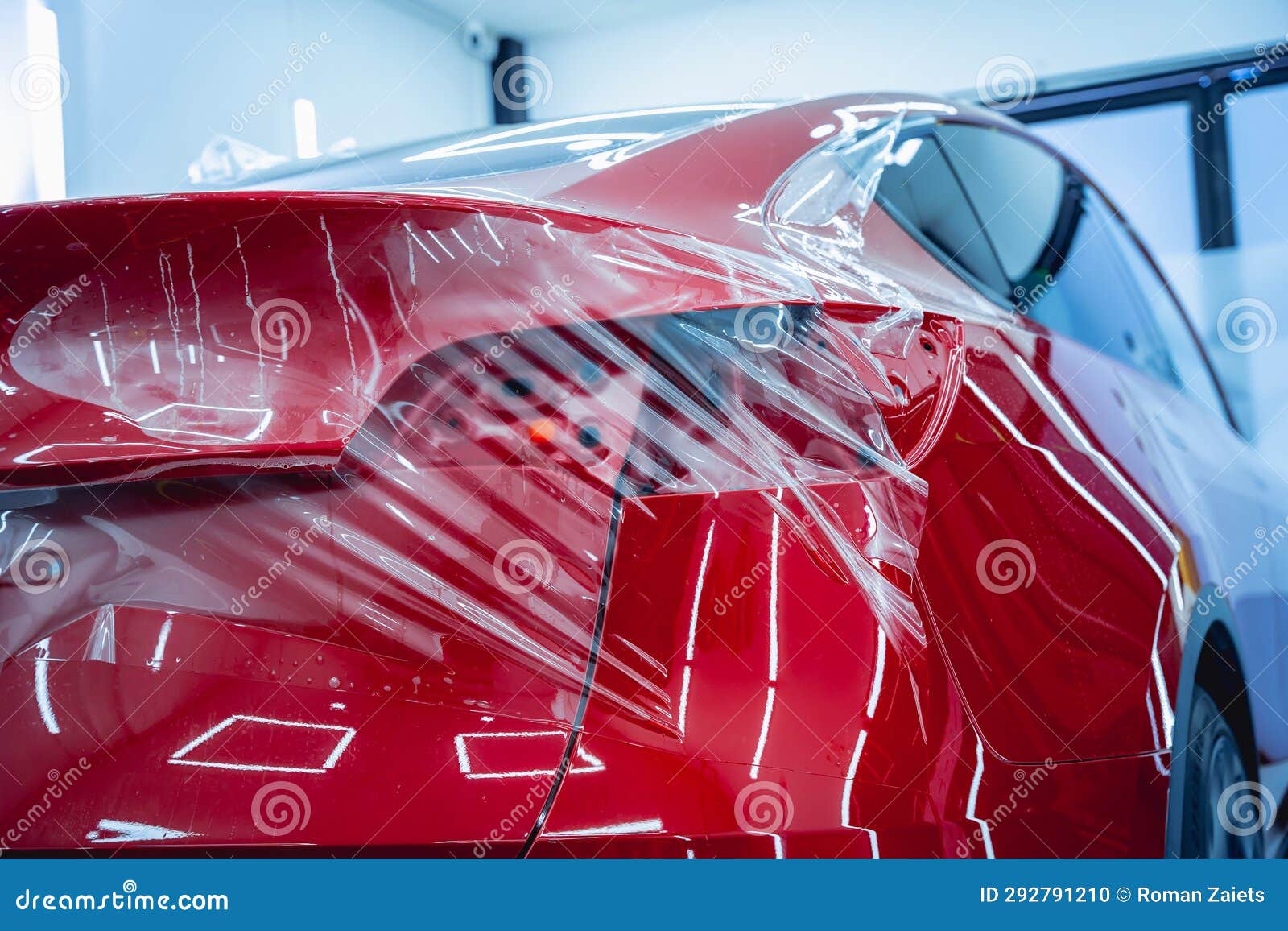 The Process of Installing Protective Film on the New Red Car. Stock