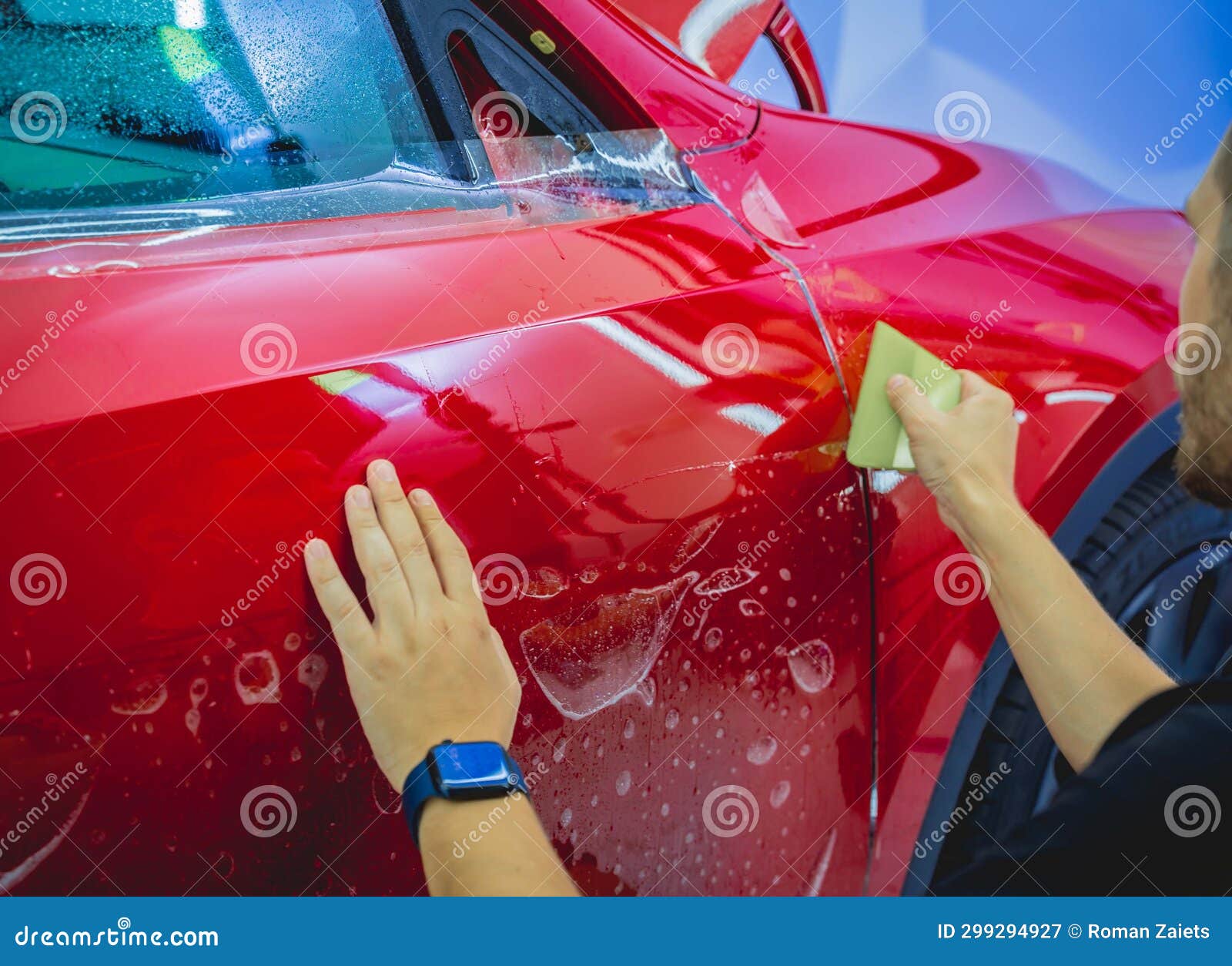 The Process of Installing Protective Film on the New Red Car. Stock