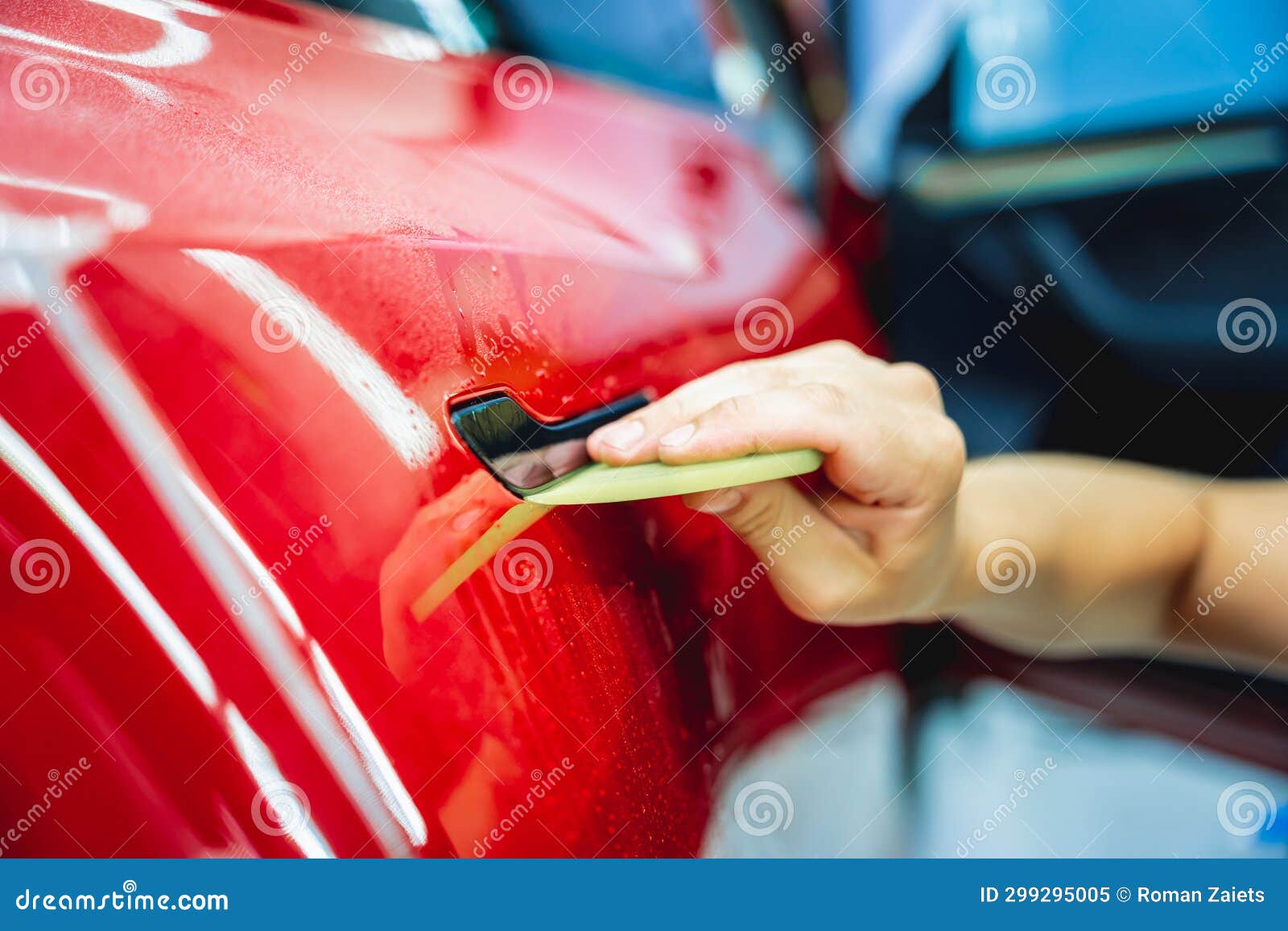 The Process of Installing Protective Film on the New Red Car. Stock
