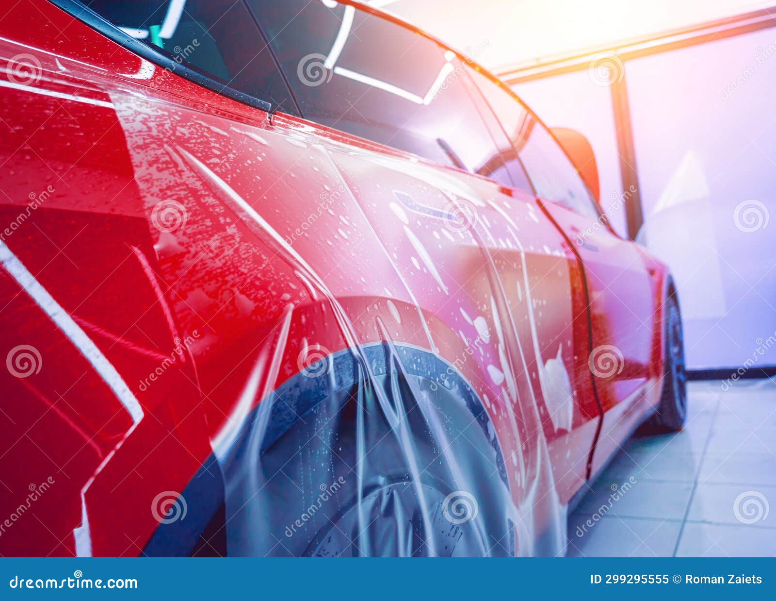 The Process of Installing Protective Film on the New Red Car. Stock