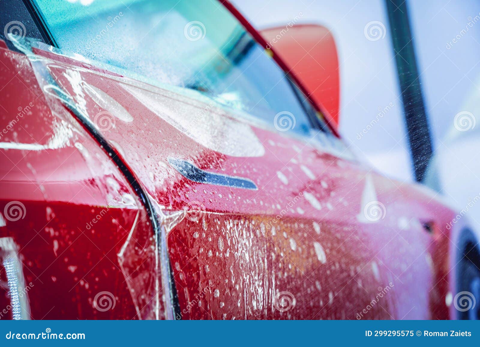 The Process of Installing Protective Film on the New Red Car. Stock