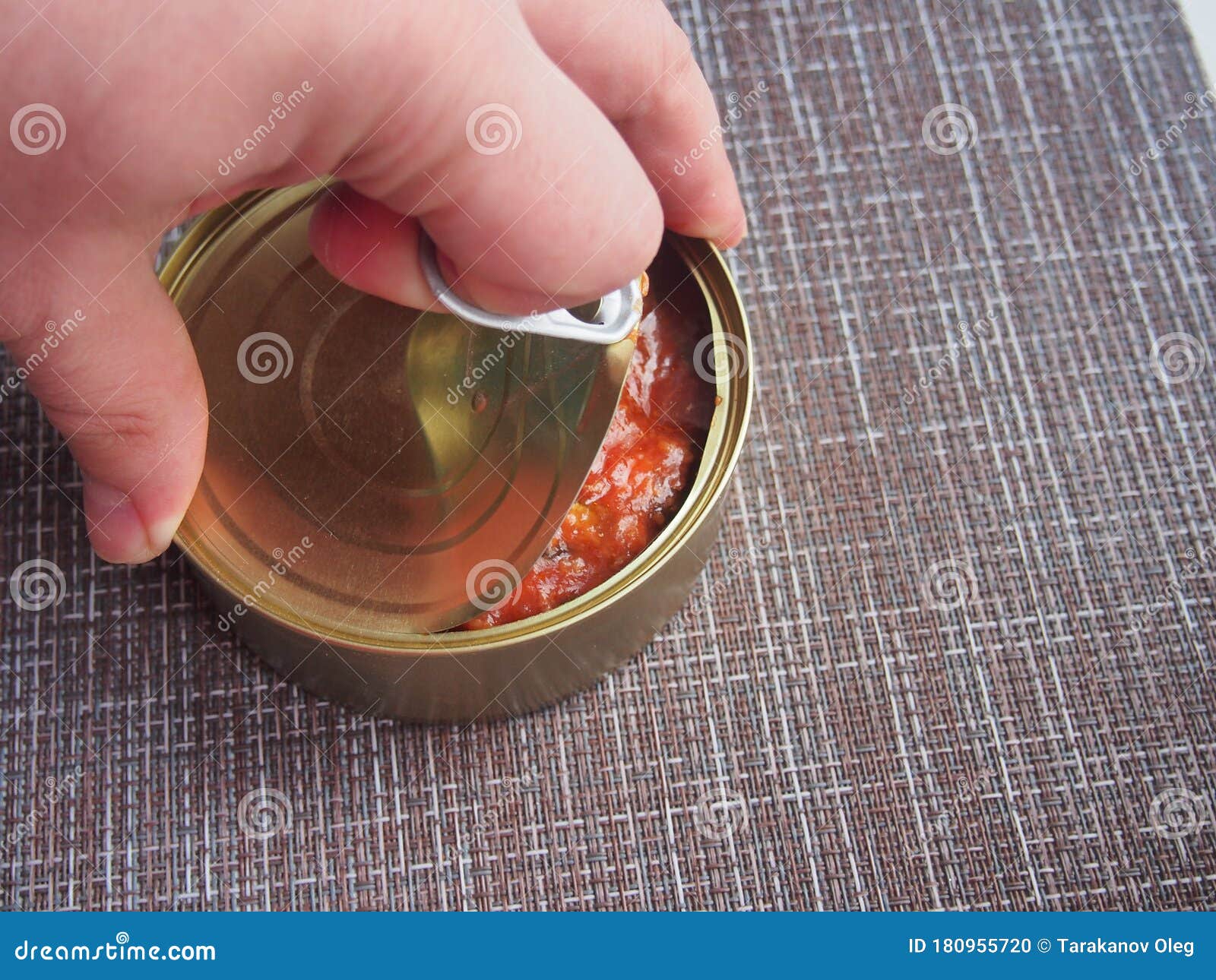 The Process of Opening a Tin Can with Canned Fish in Tomato Sauce Stock