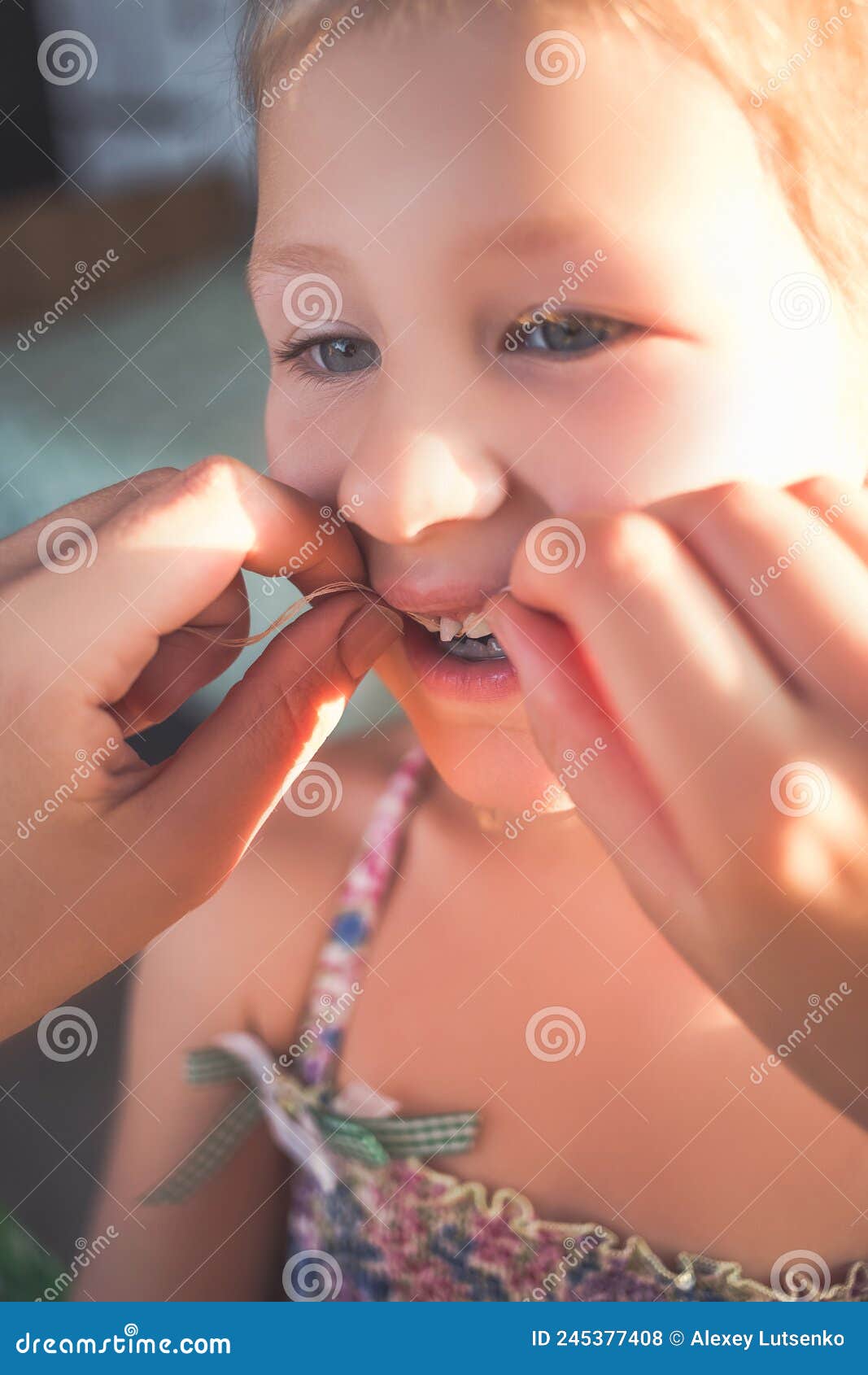 The Process of Removing a Baby Tooth Using a Thread Stock Photo Image