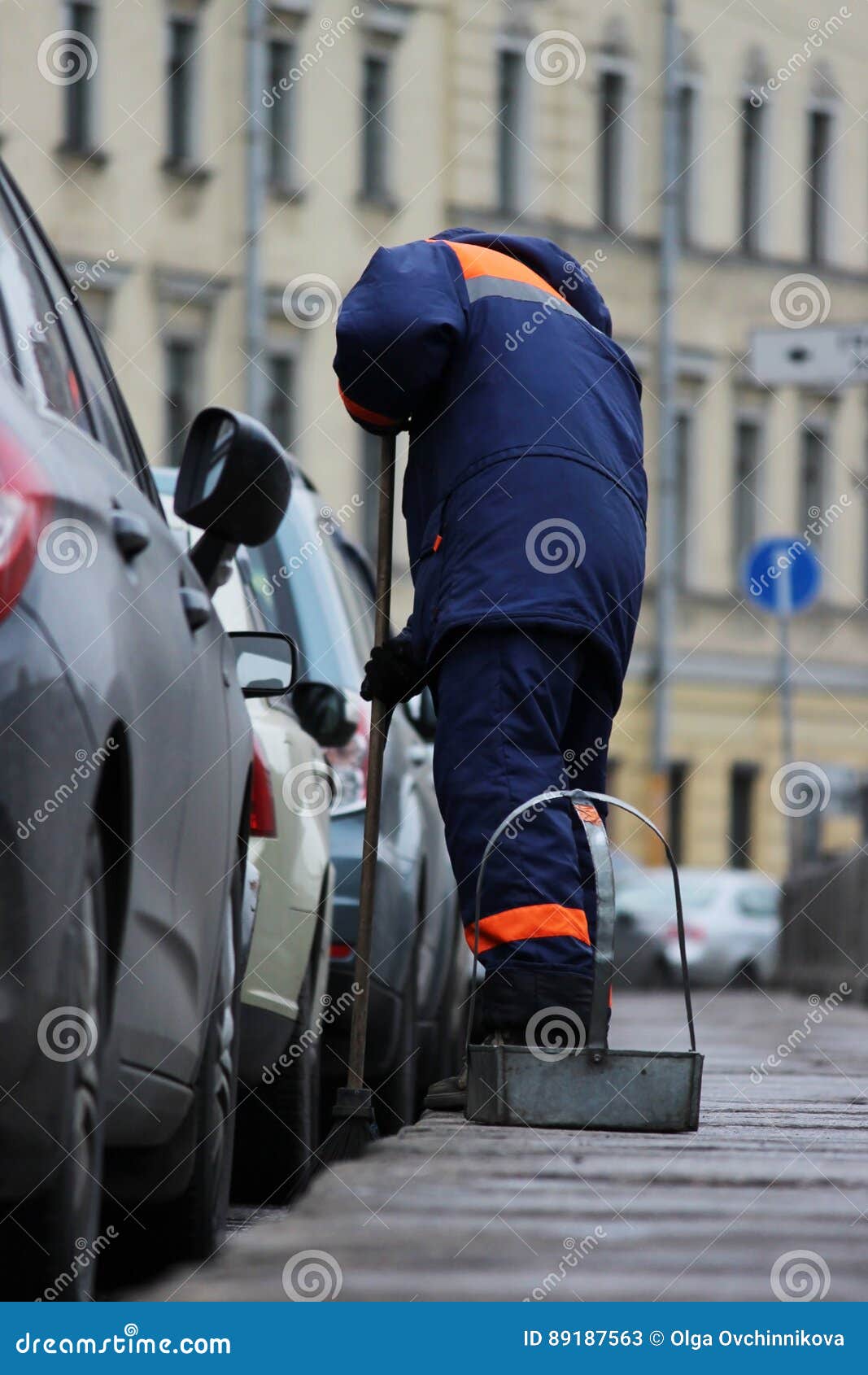 Process of Urban Street Cleaning Sweeping. Worker with Broom and Dust