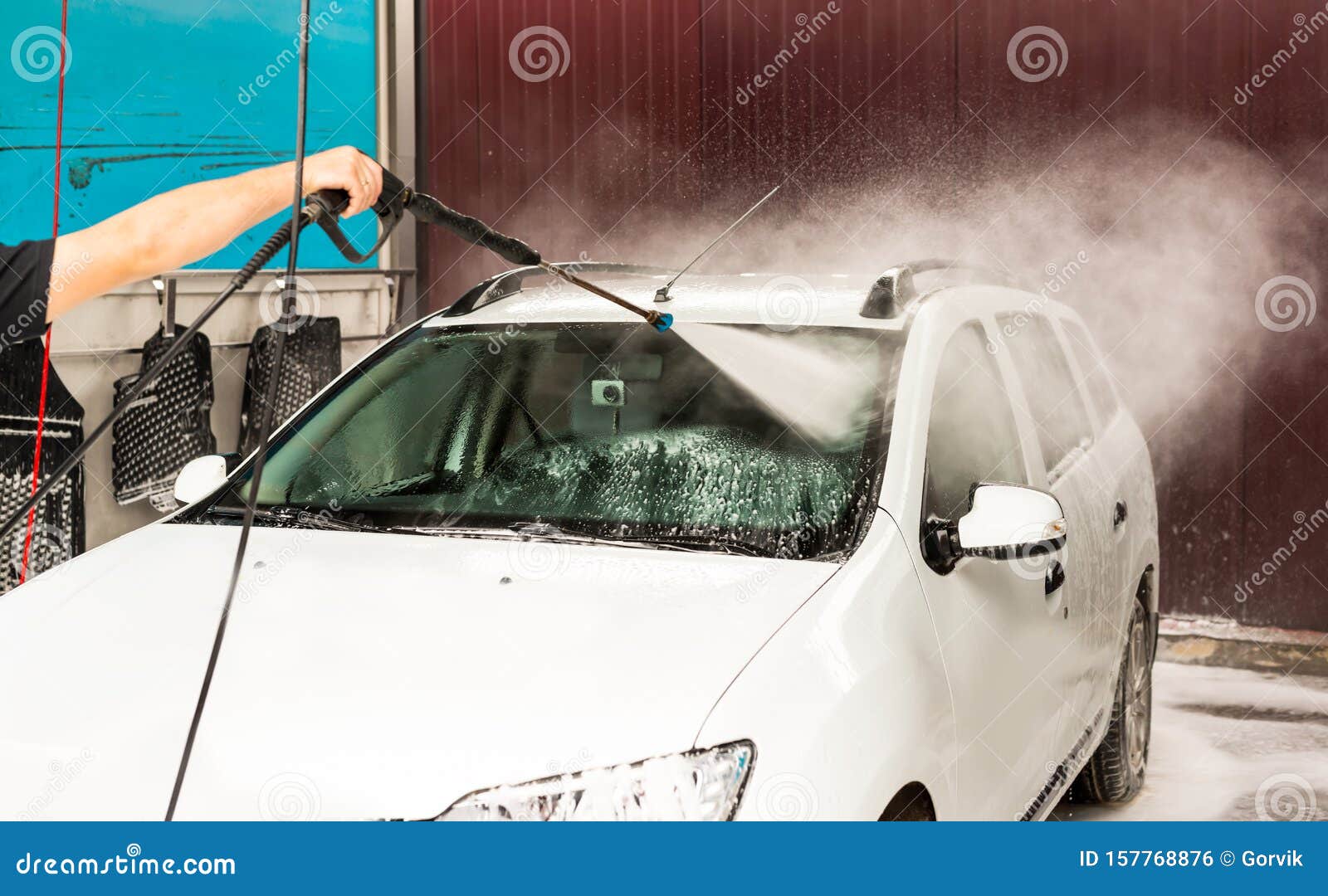 The Process of Washing the Windshield of a Car Using a Pressure Washer