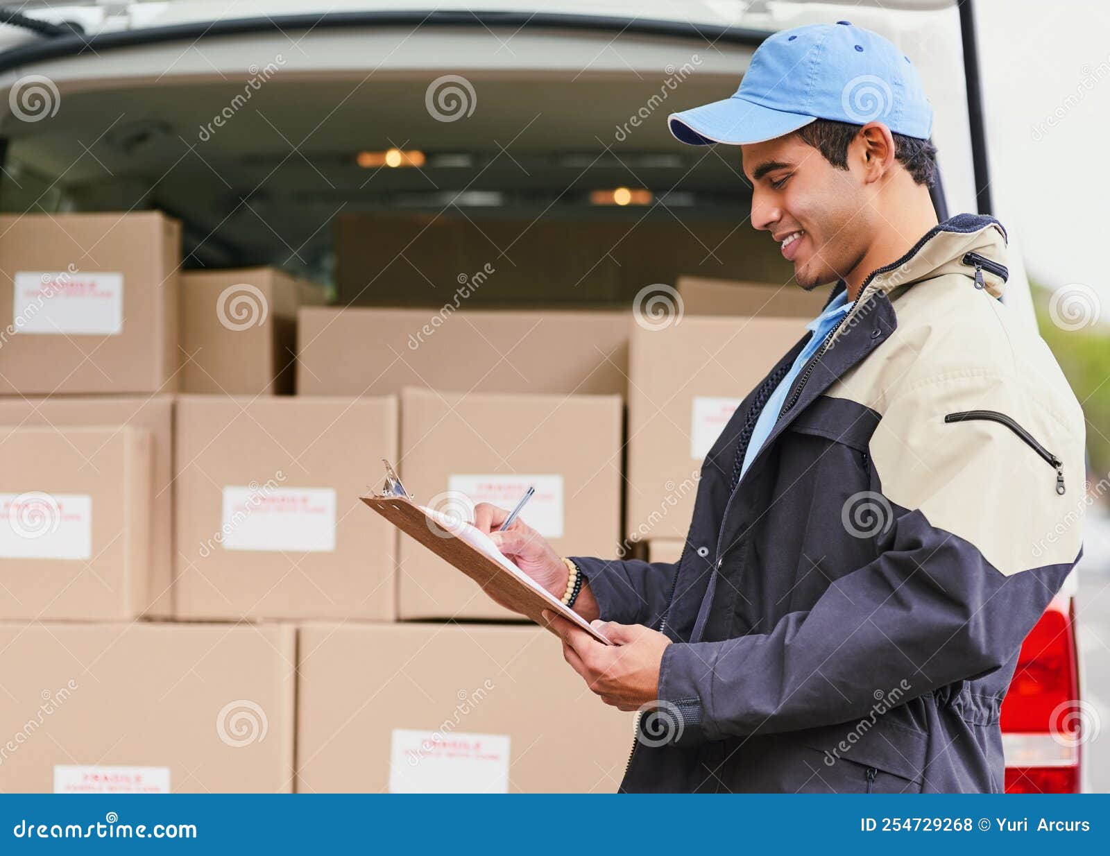 Processing His Deliveries for the Day. a Delivery Man Writing on a