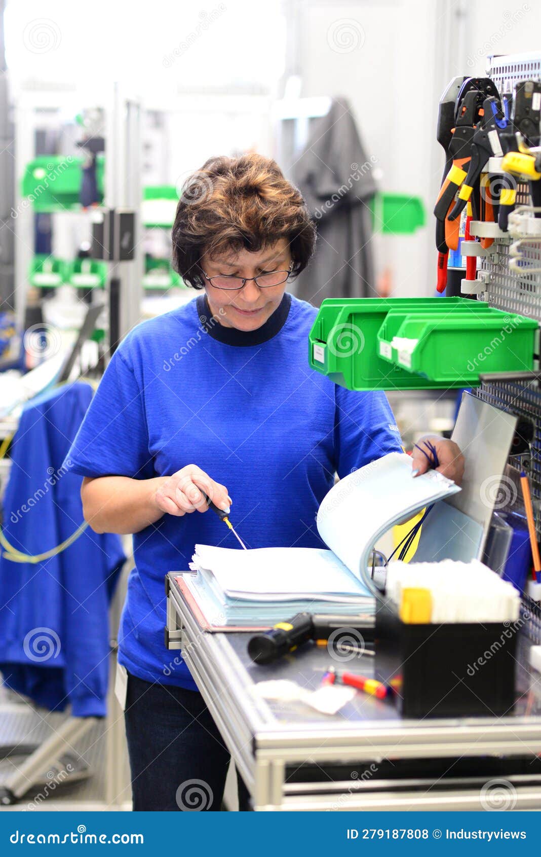 production and assembly of microelectronics in a hi-tech factory - older woman assembles components