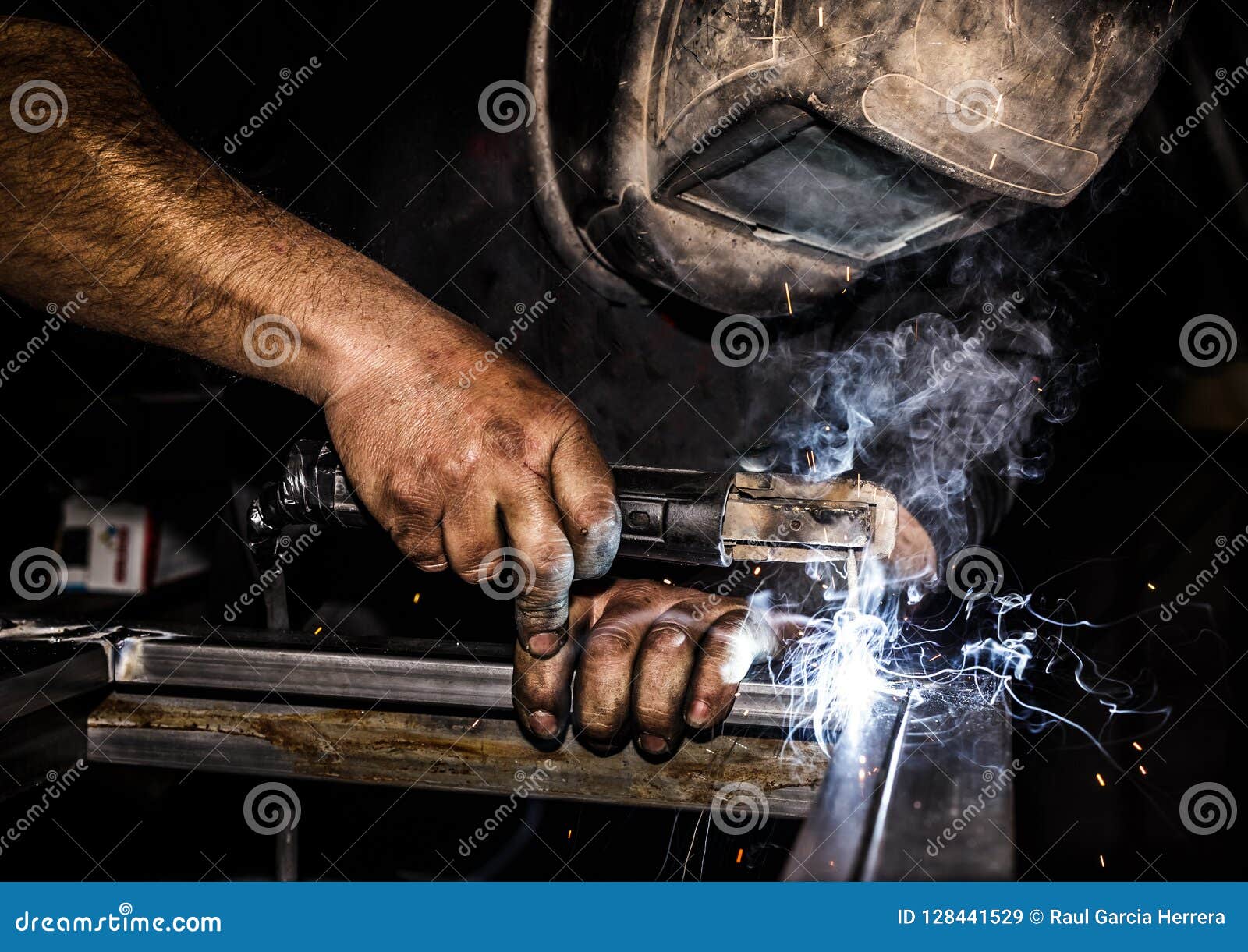 profesional welder in protective mask welding metal and sparks metal