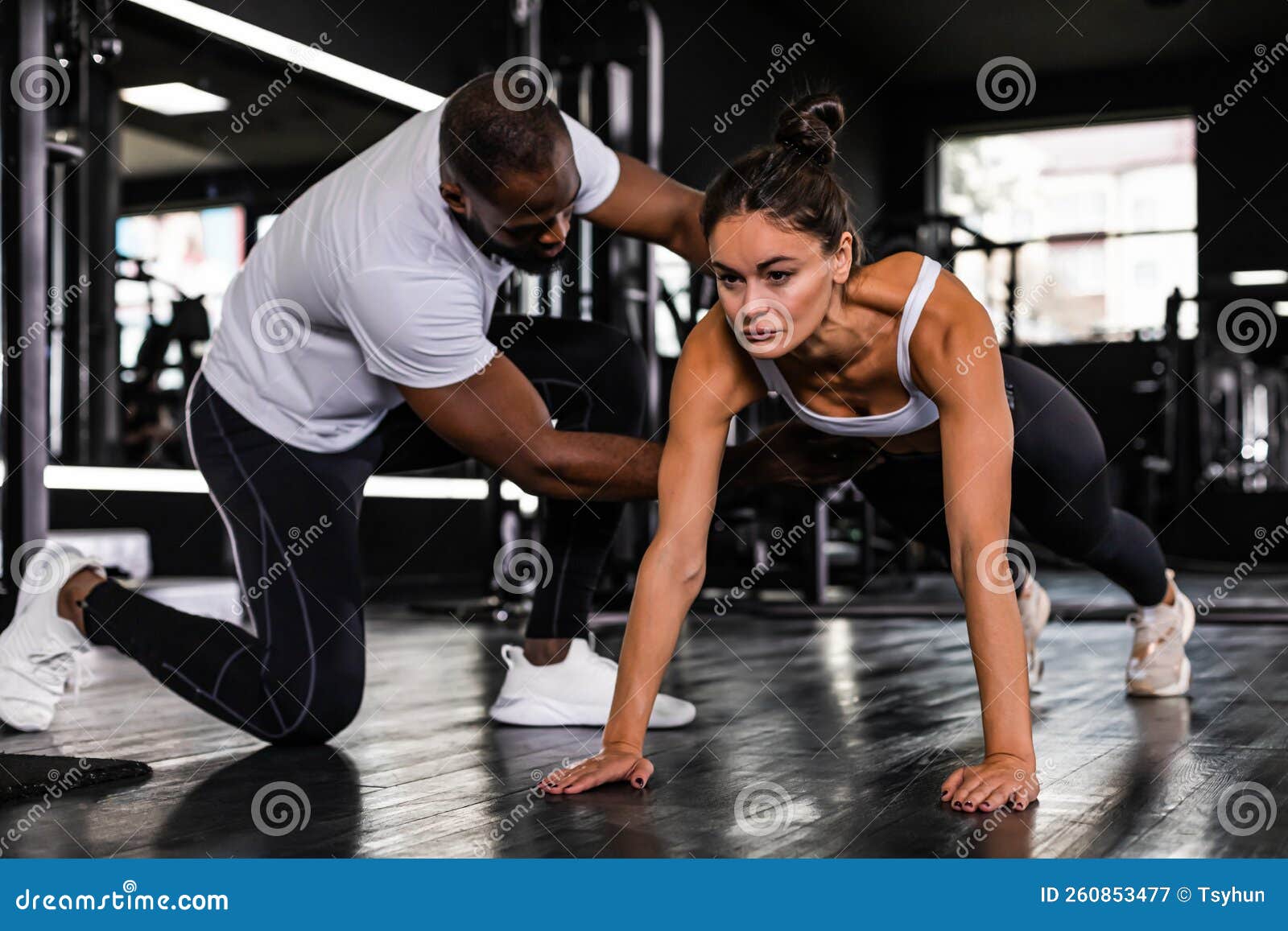 Profesor De Fitness Haciendo Ejercicio Con Su Cliente En El Gimnasio Hombre  Africano Y Mujer Caucásica. Imagen de archivo - Imagen de equipo, sitio:  260853477