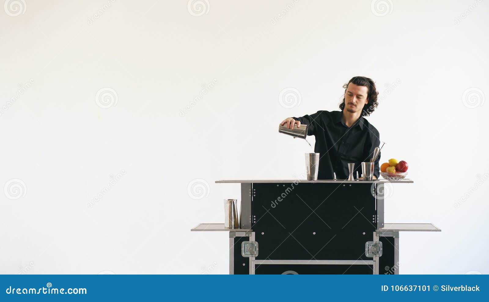 professinal bartender man shaking cocktail at mobile bar table on white background