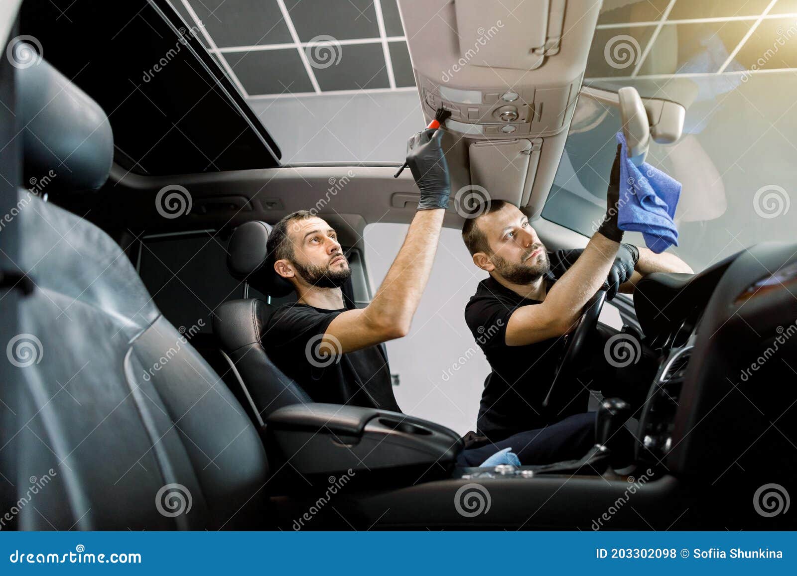 Professional Auto Detailing. Two Men Car Service Workers Cleaning