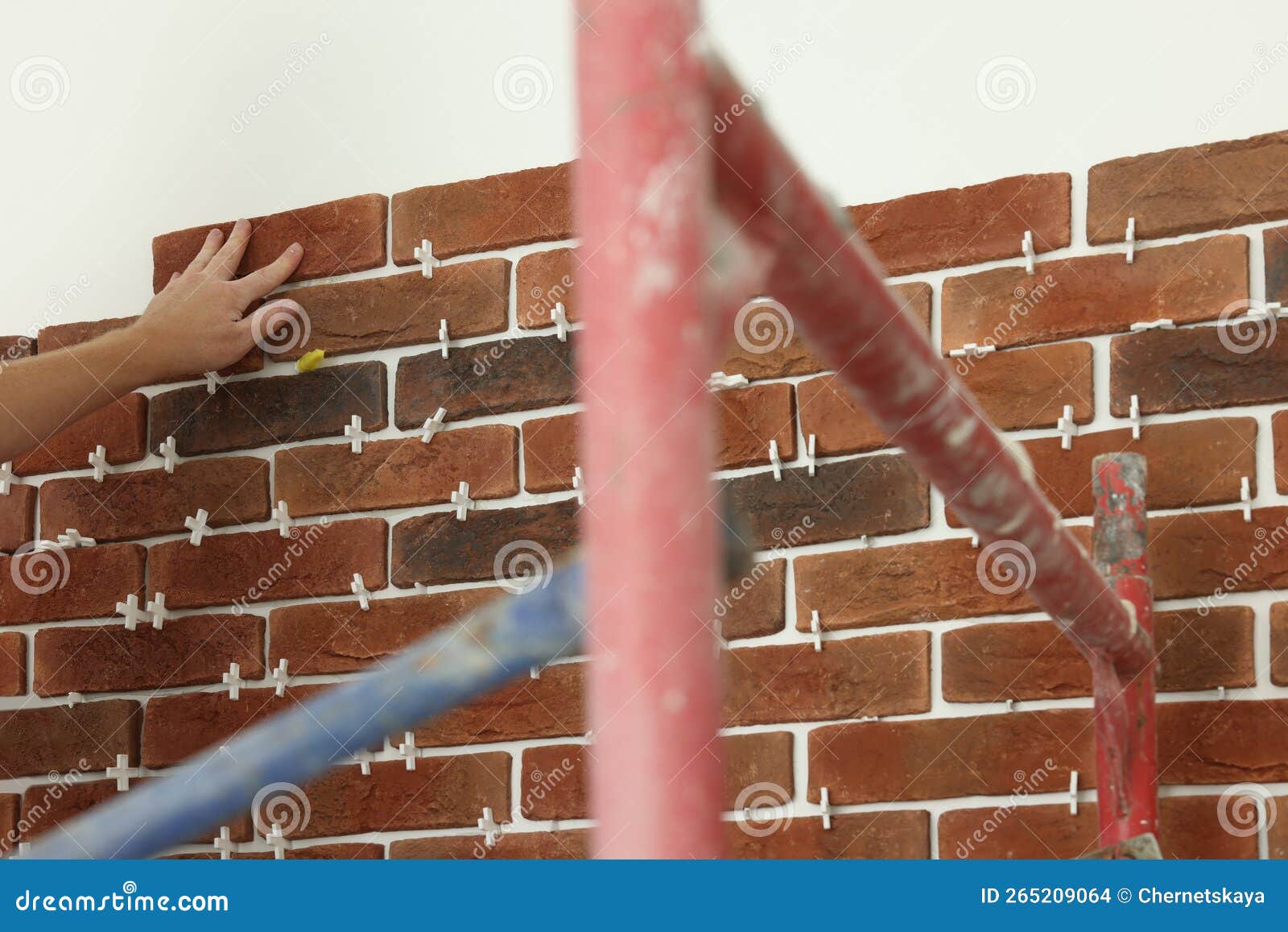 Professional Builder Gluing Decorative Brick on Wall, Closeup. Tiles