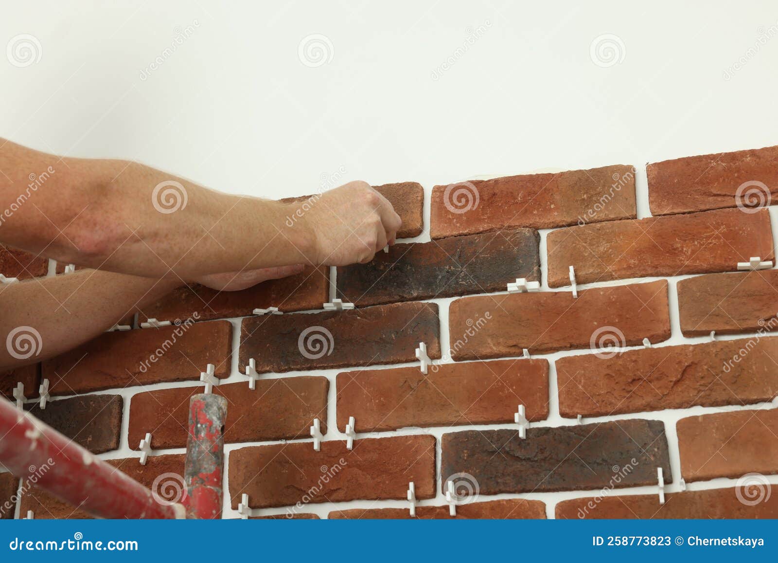 Professional Builder Gluing Decorative Brick on Wall, Closeup. Tiles