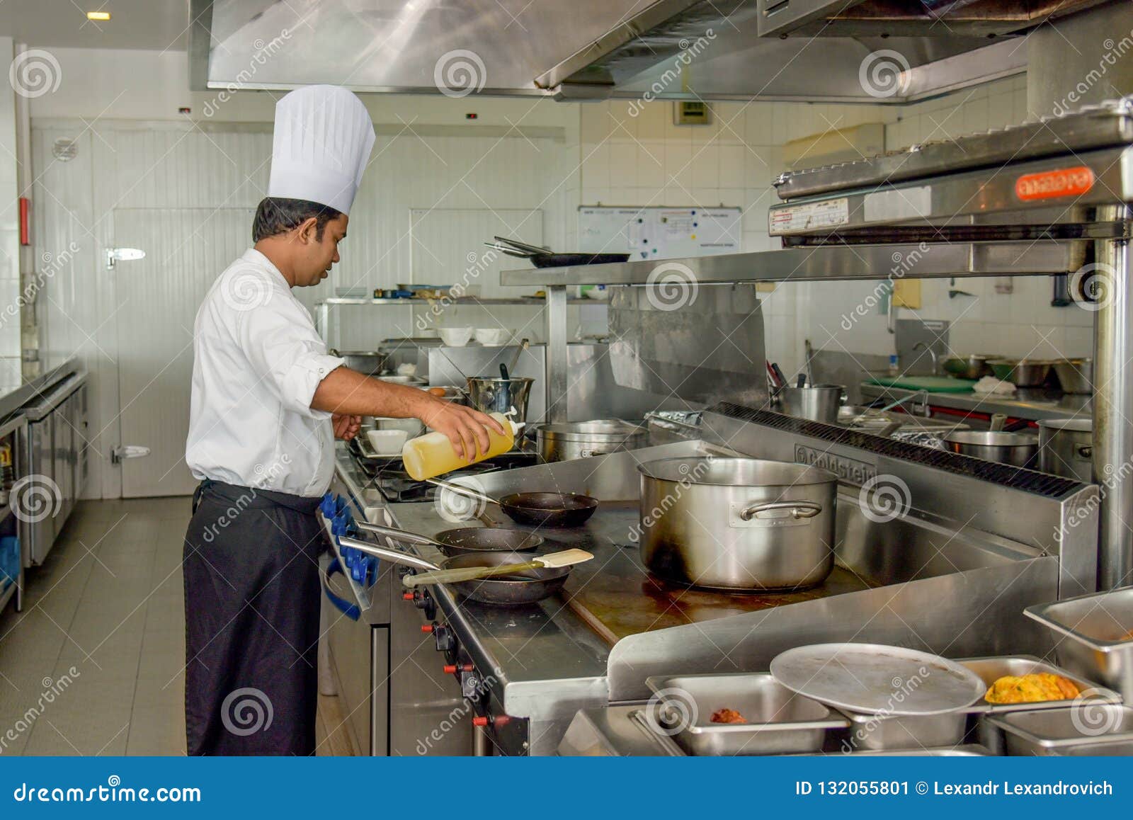 Professional Chef Putting Oil on the Skillet at the Kitchen Editorial