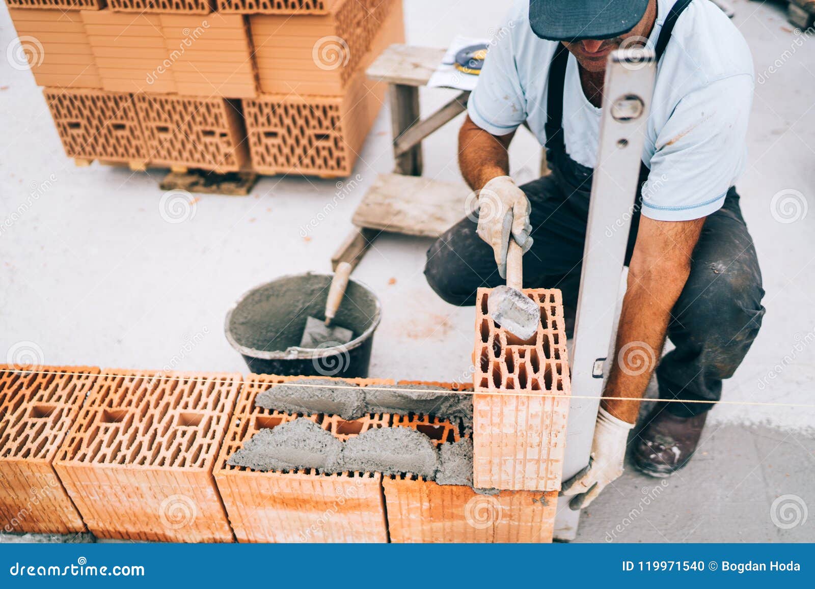 professional construction worker building walls and bricklaying rows of bricks