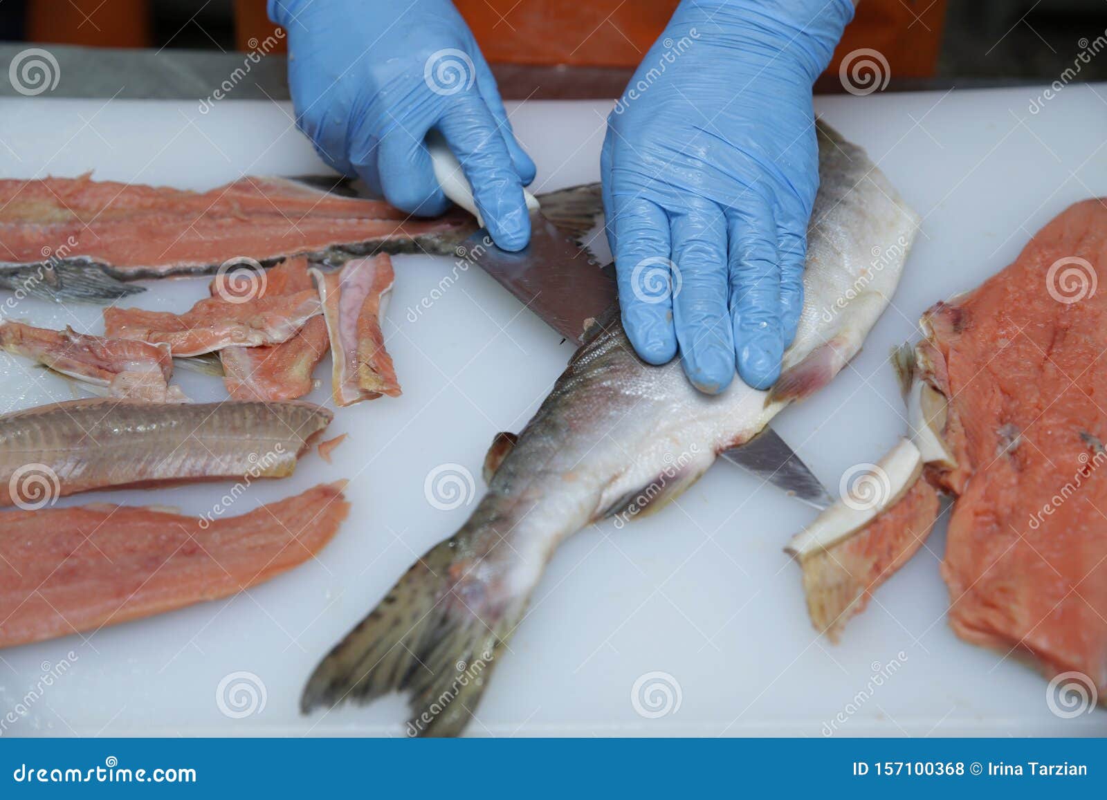 Professional Cutting of Raw Red Salmon Fish. Hands with a Knife