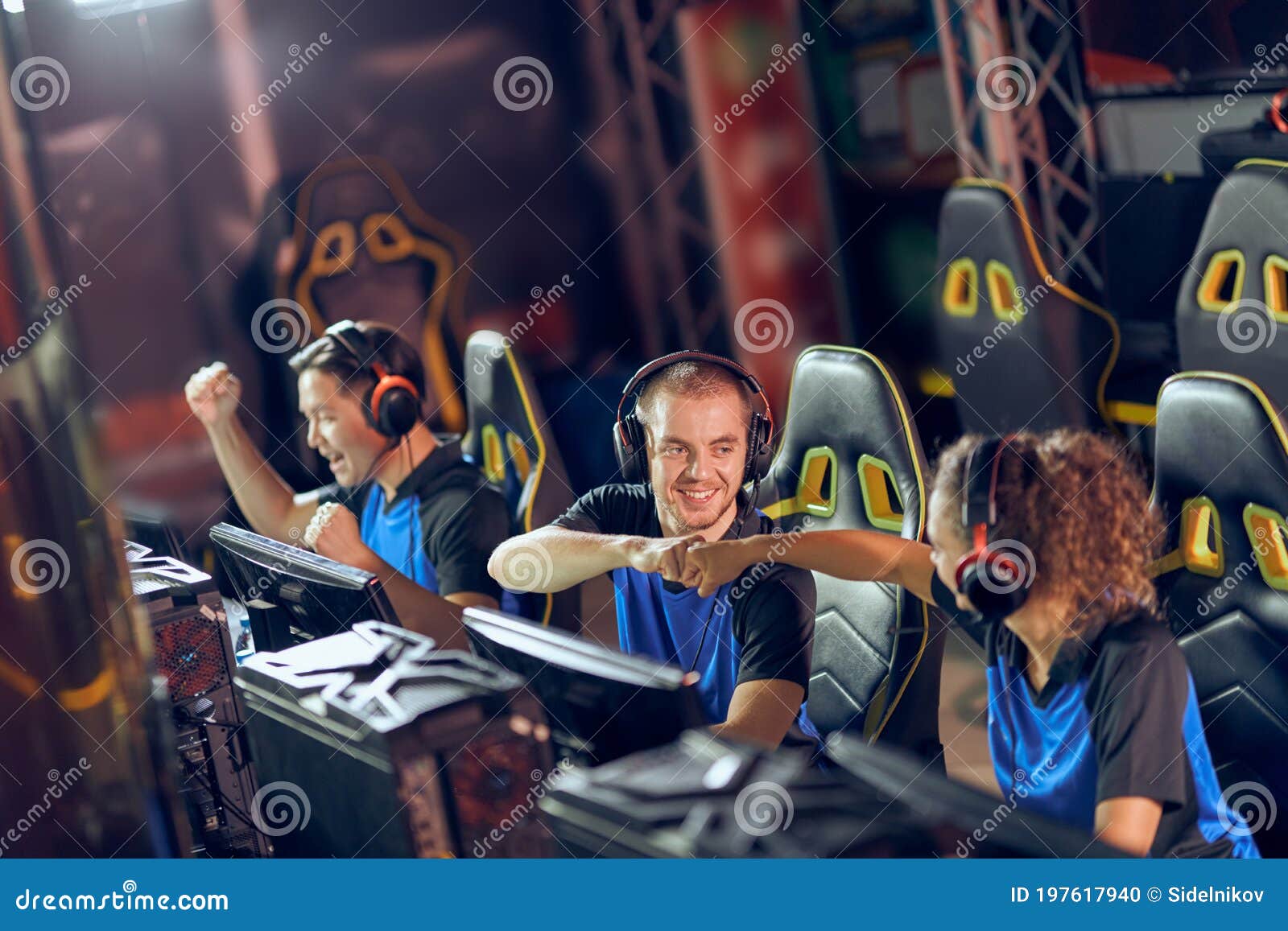 Professional Cyber Sport Gamers Giving Fist Bump and Celebrating Success while Participating in ESports Tournament Stock Photo