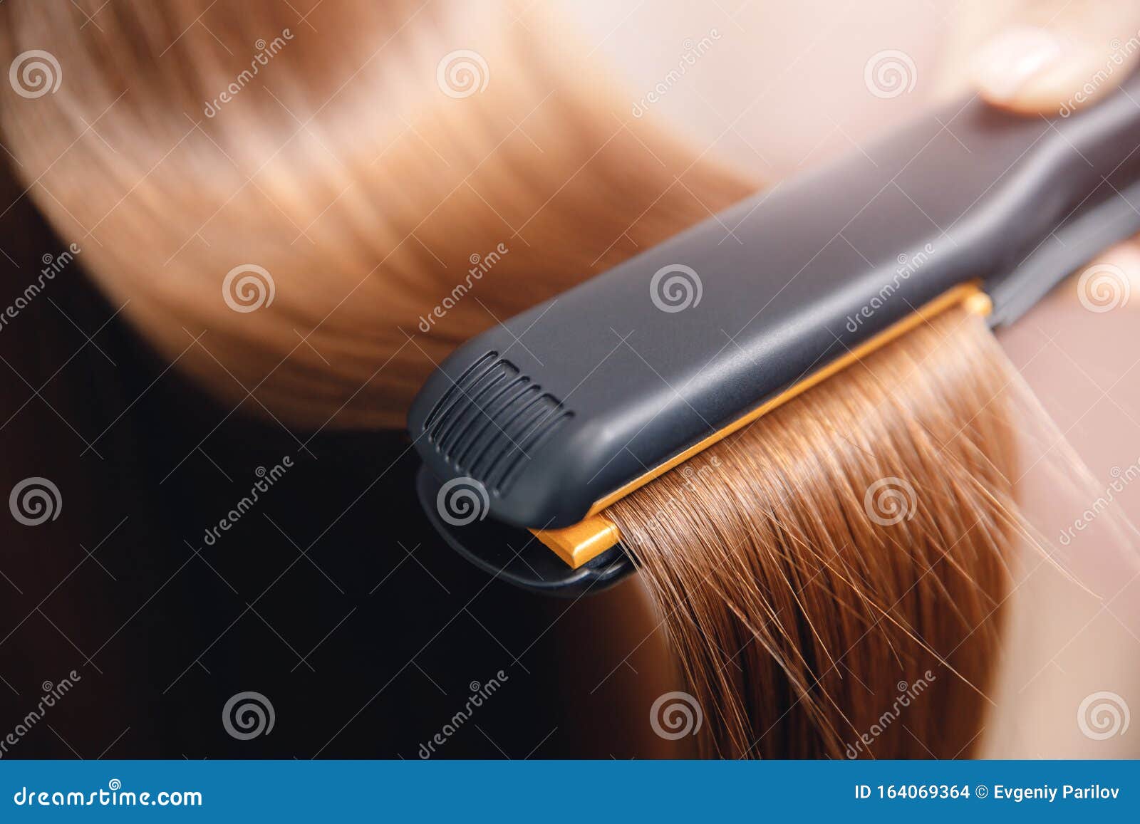 Hair Iron In Hand Of Master Straightens With Keratin Stock Photo