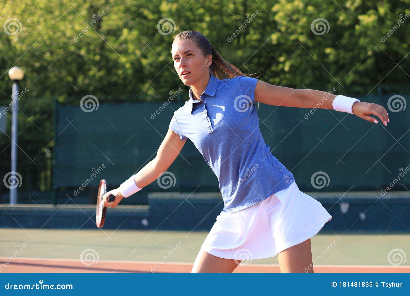 Professional Equipped Female Tennis Player Beating Hard The Tennis Ball With Racquet Stock Image