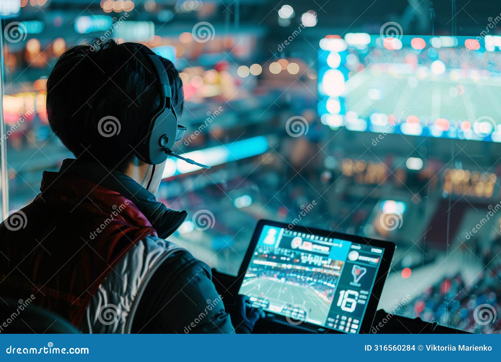 professional football commentator in headphones behind monitor screen commenting on football match