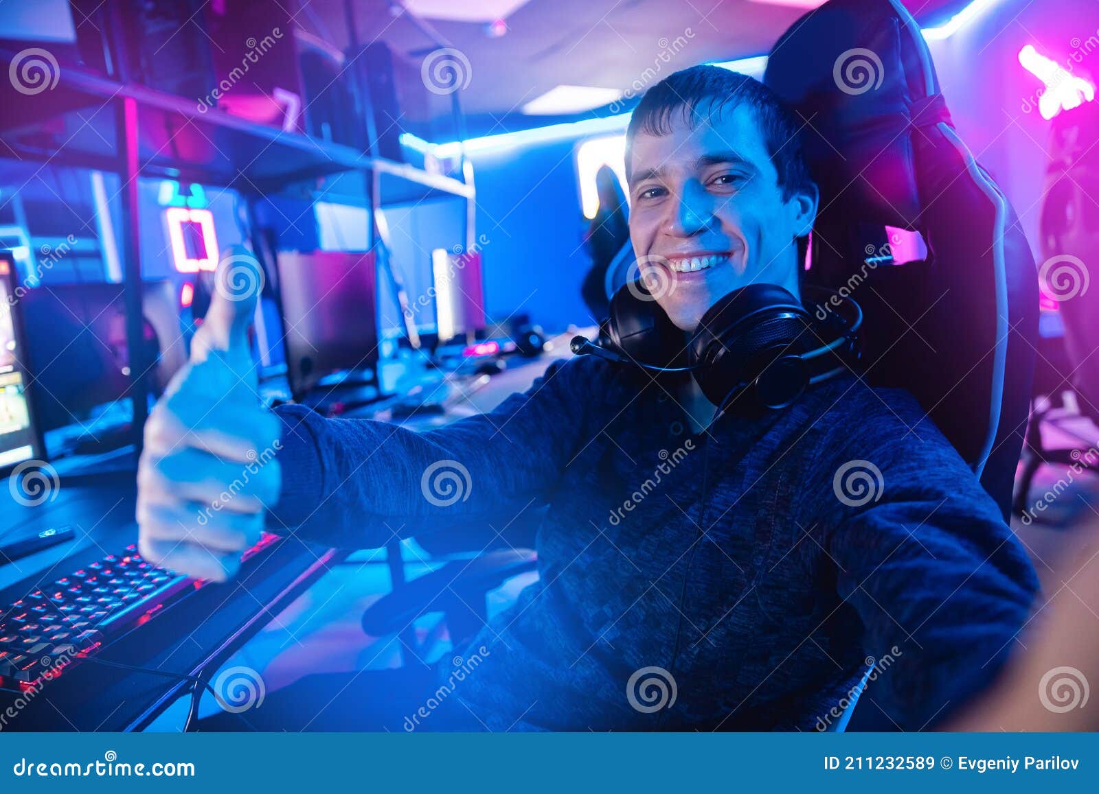 Professional Gamer Man Smile Making Selfie Photo and Playing Tournaments Online Video Games Computer with Headphones Stock Image