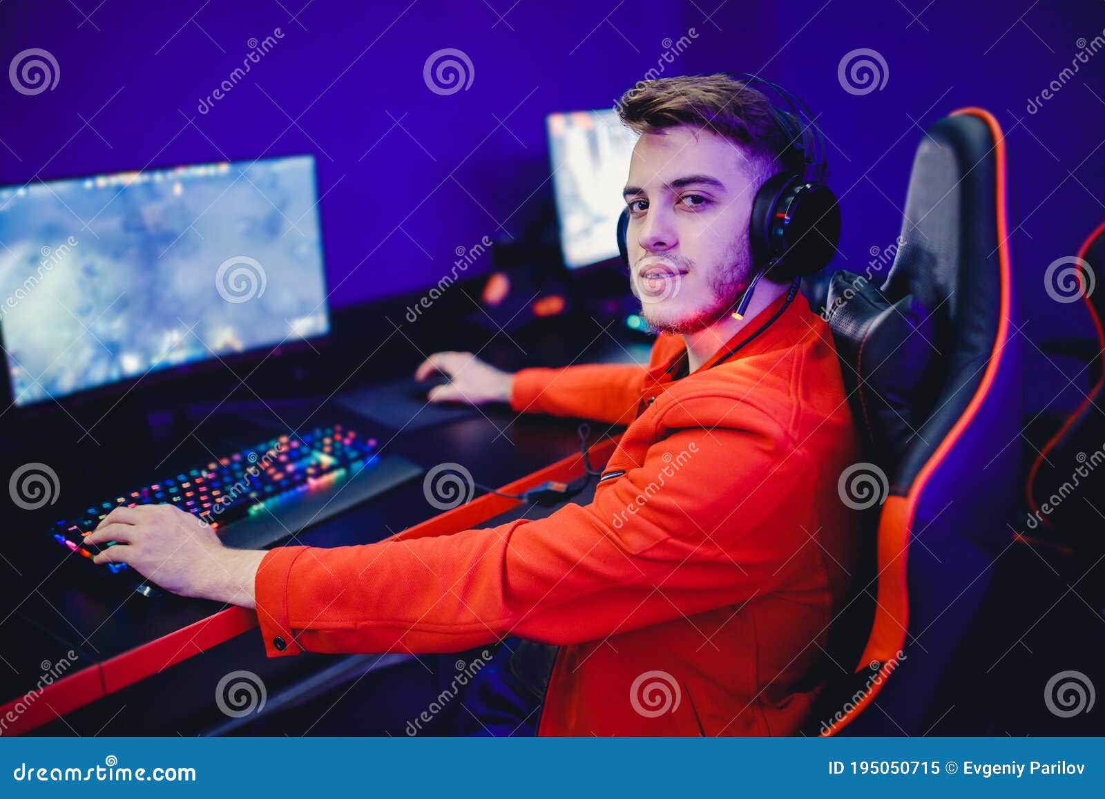 Professional Gamer Playing Tournaments Online Video Games Computer with Headphones, Red and Blue Stock Image