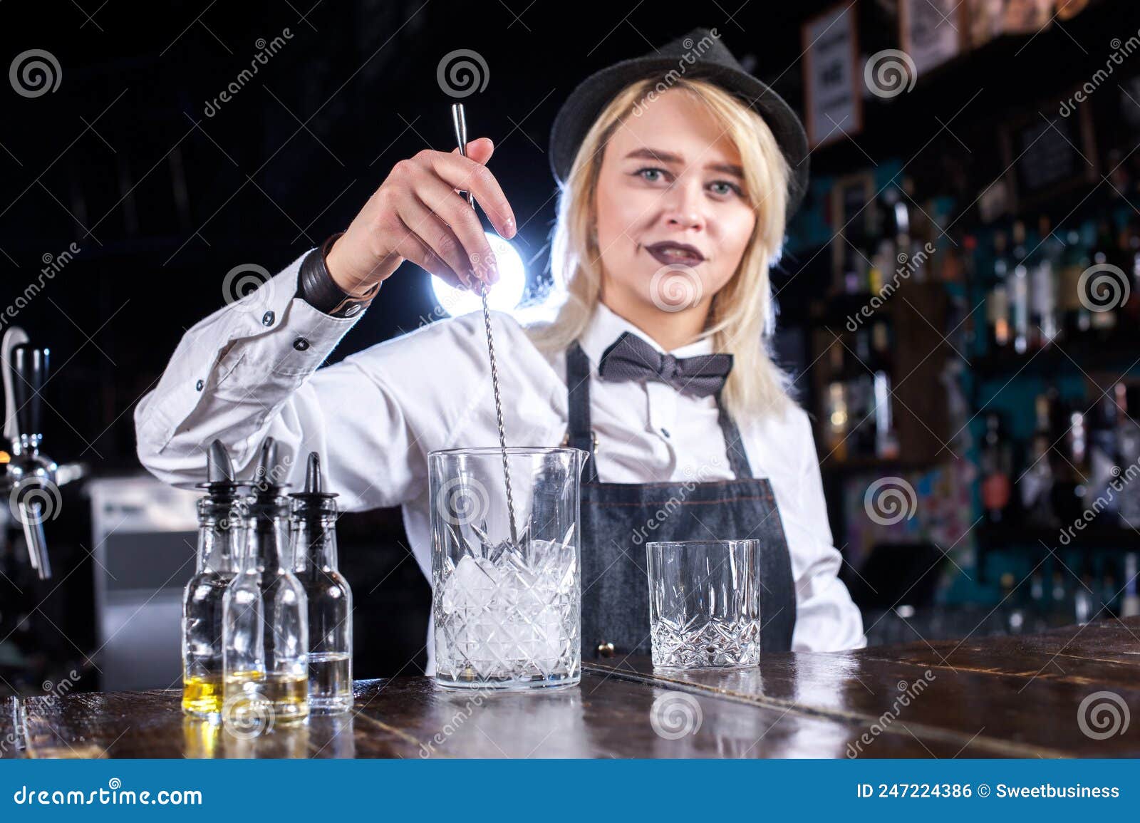 Portrait of Woman Bartending Adds Ingredients To a Cocktail while ...