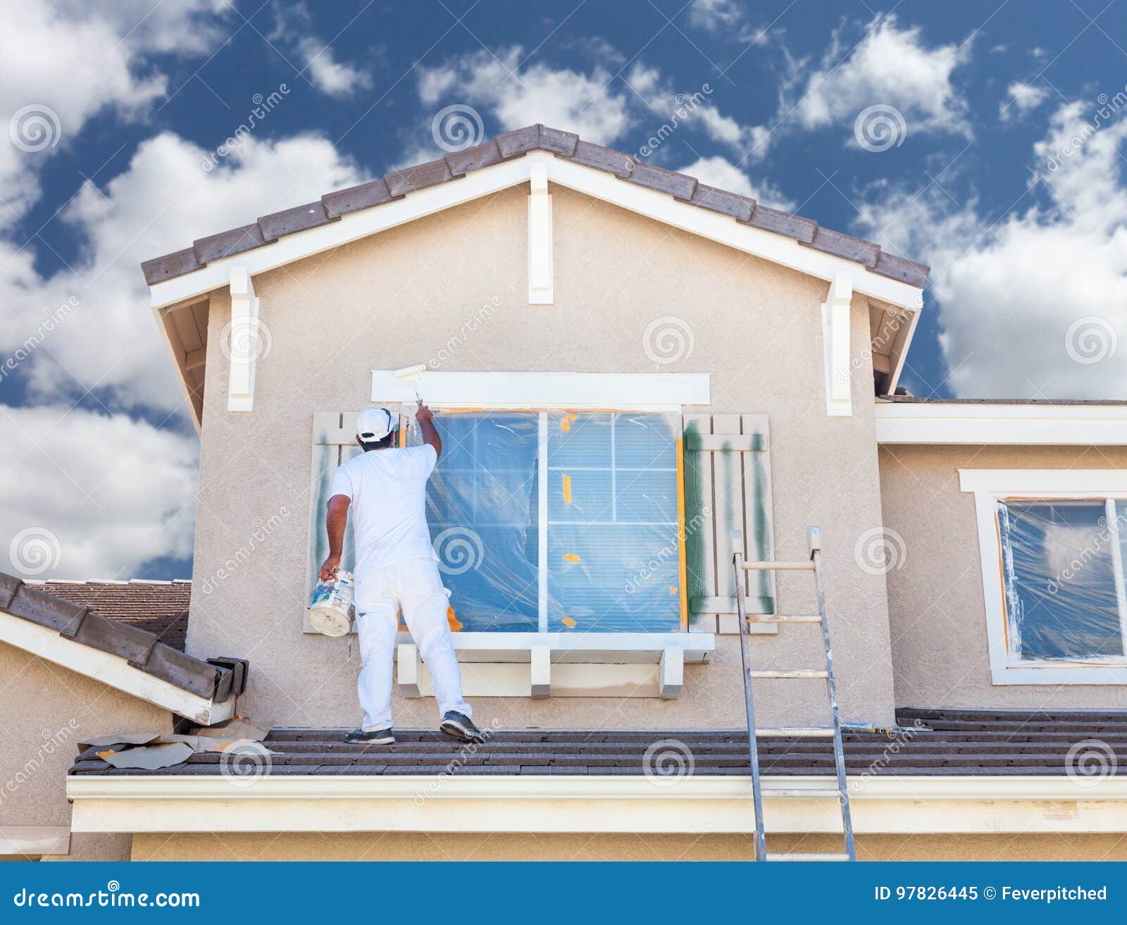professional house painter painting the trim and shutters of a h