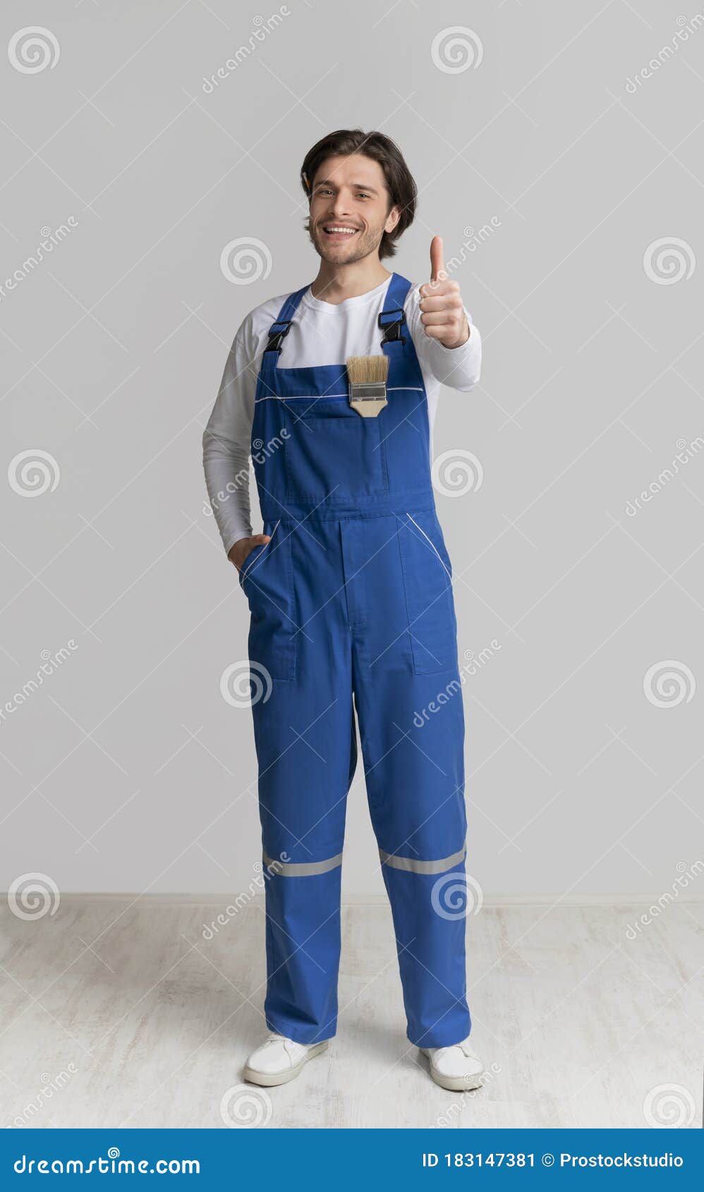 Professional House Painter in Work Uniform Gesturing Thumb Up Stock