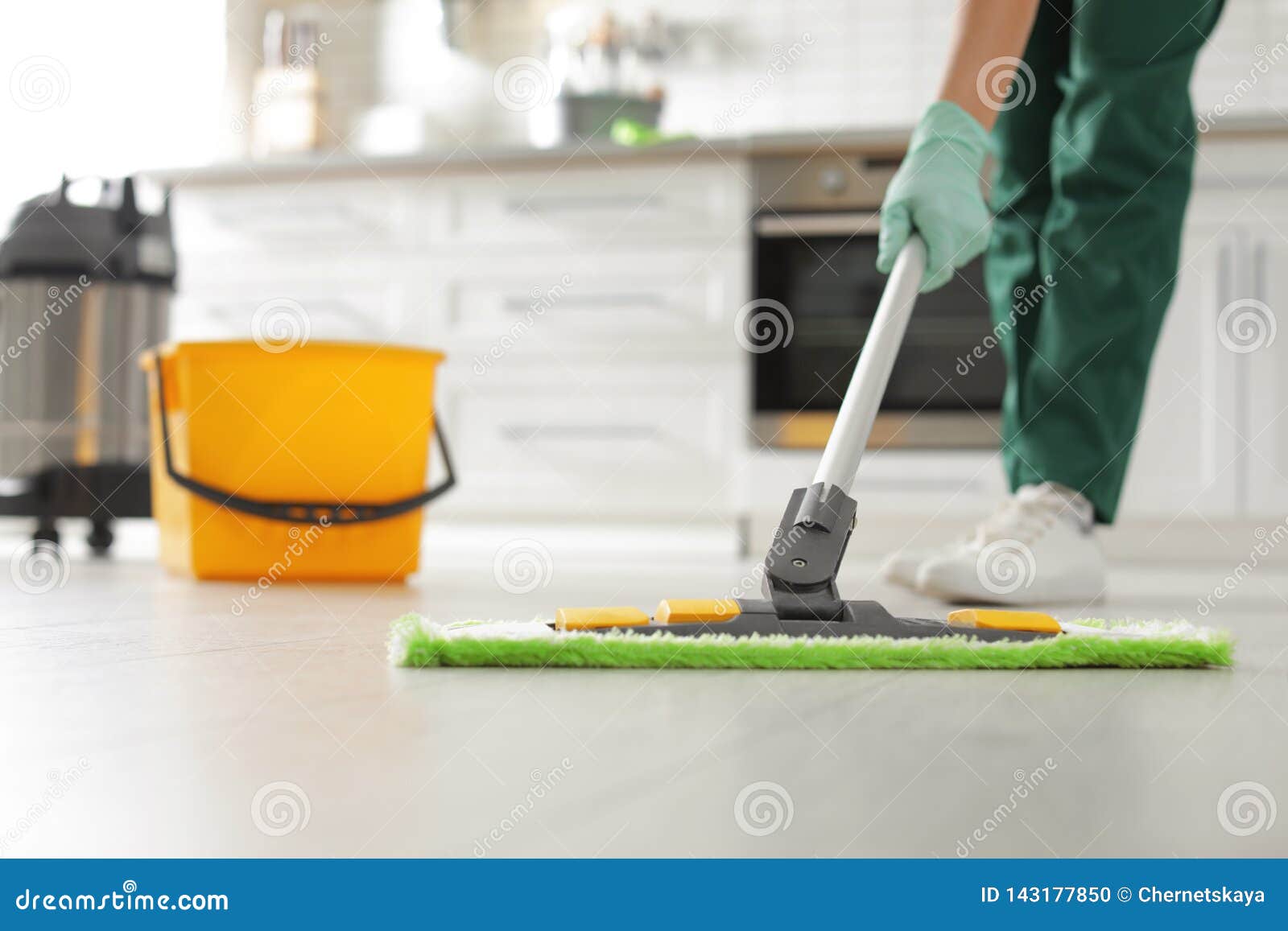 Professional Janitor Cleaning Floor With Mop In Kitchen Stock