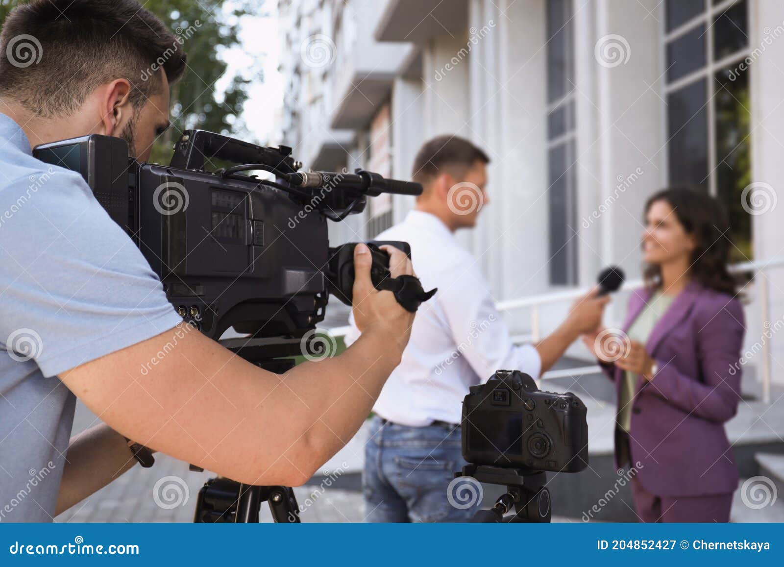 Professional Journalist and Operator with Video Camera Taking Interview