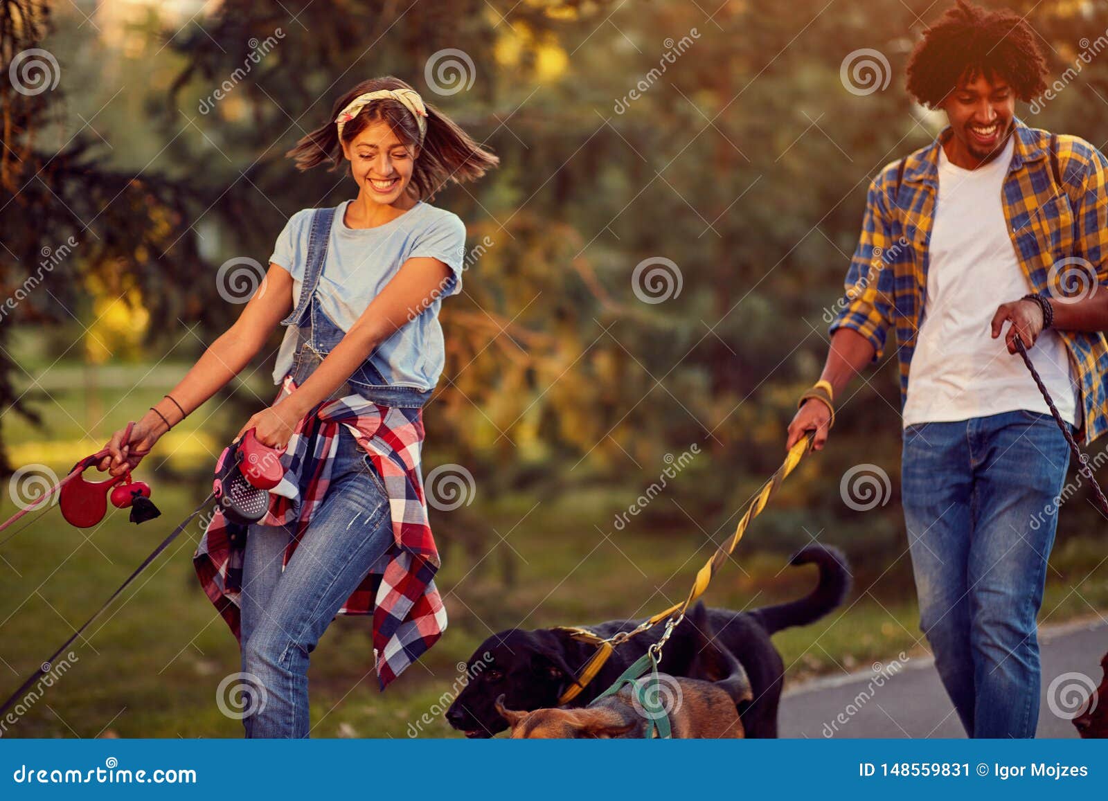 professional man and woman dog walkers with dog enjoying in park