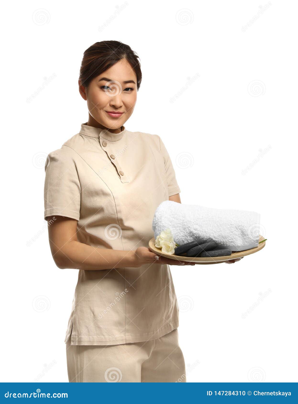 Professional Masseuse In Spa Uniform Holding Tray With Towel And Rocks