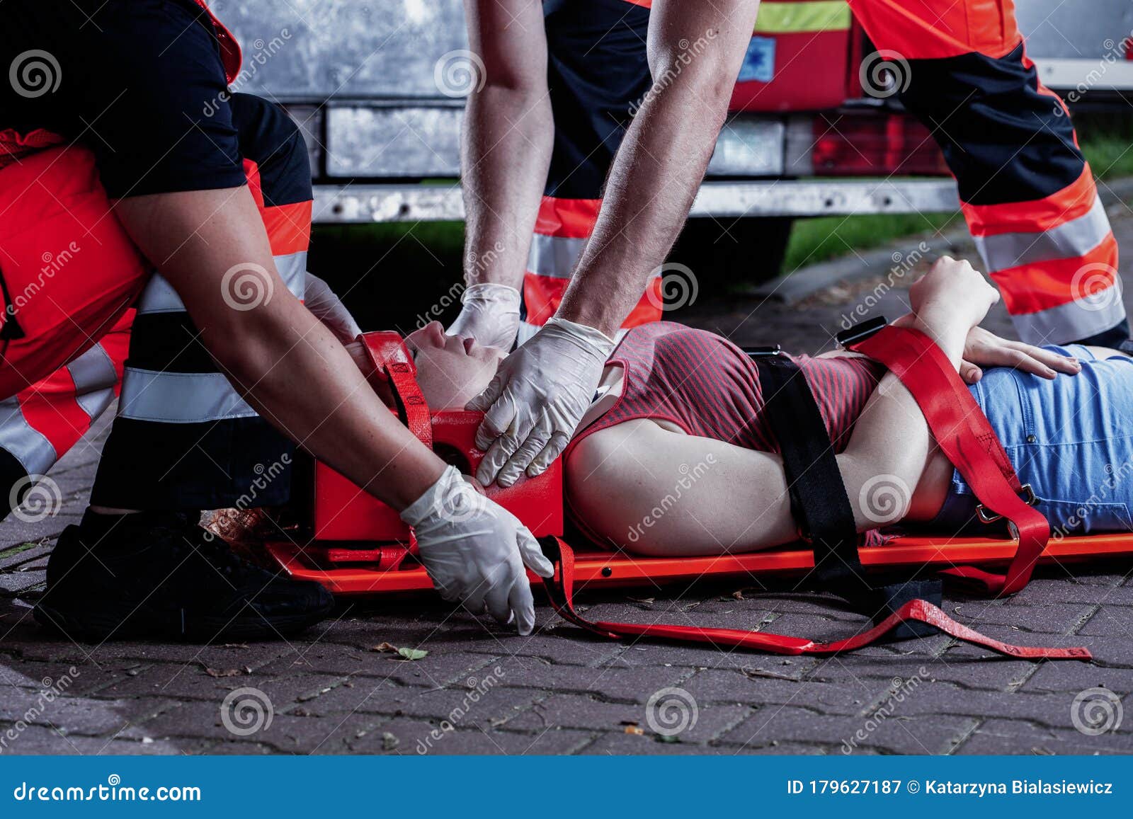 medical rescuer bending over a car accident victim lying on a stretcher