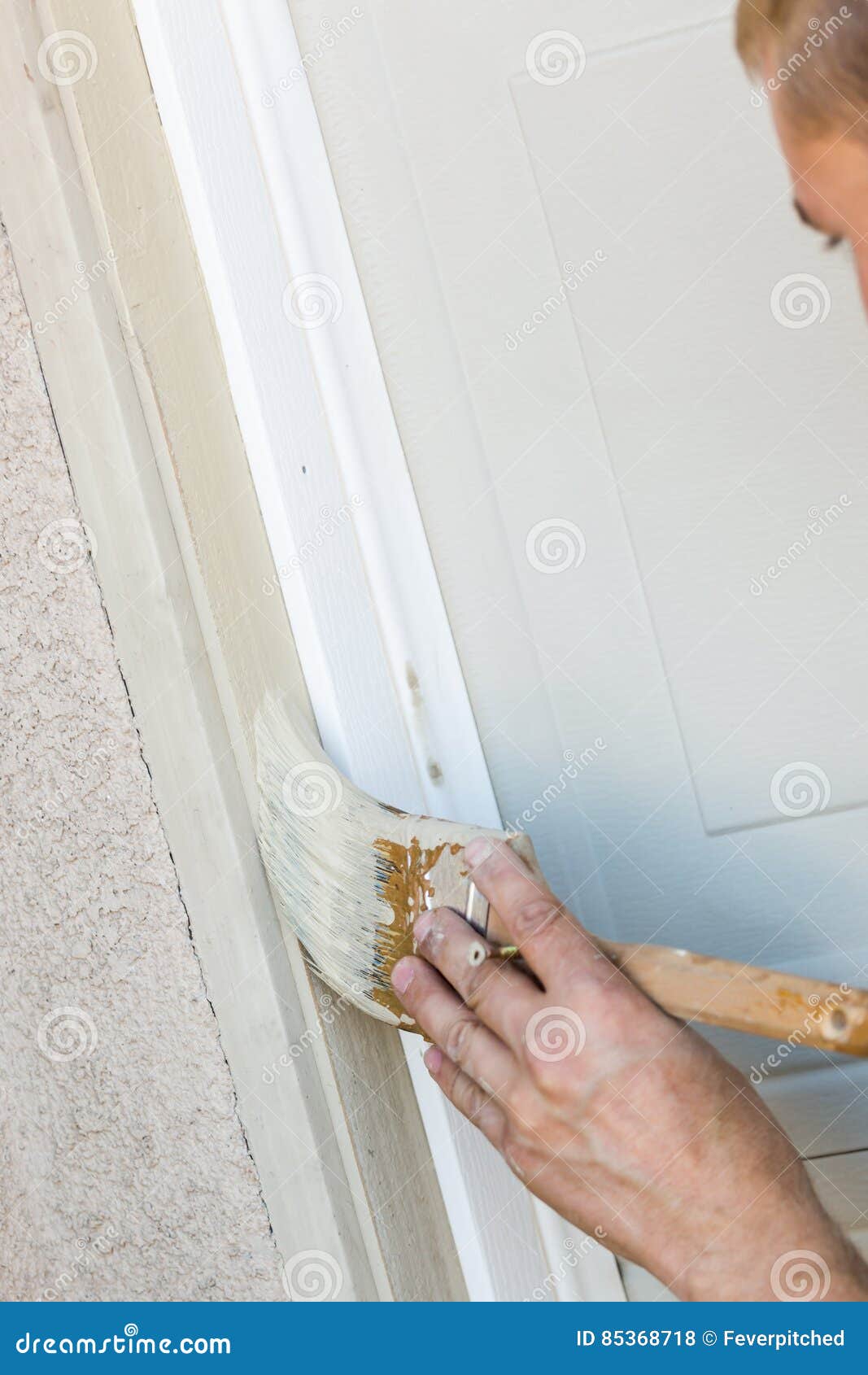 Professional Painter Cutting in with Brush To Paint Garage Door Stock