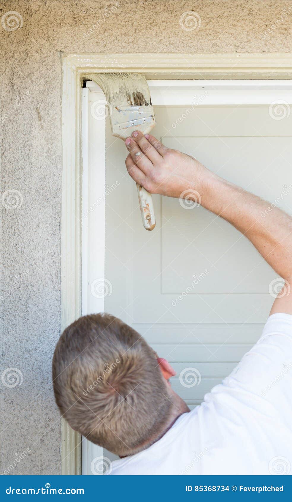 Professional Painter Cutting in with Brush To Paint Garage Door Stock