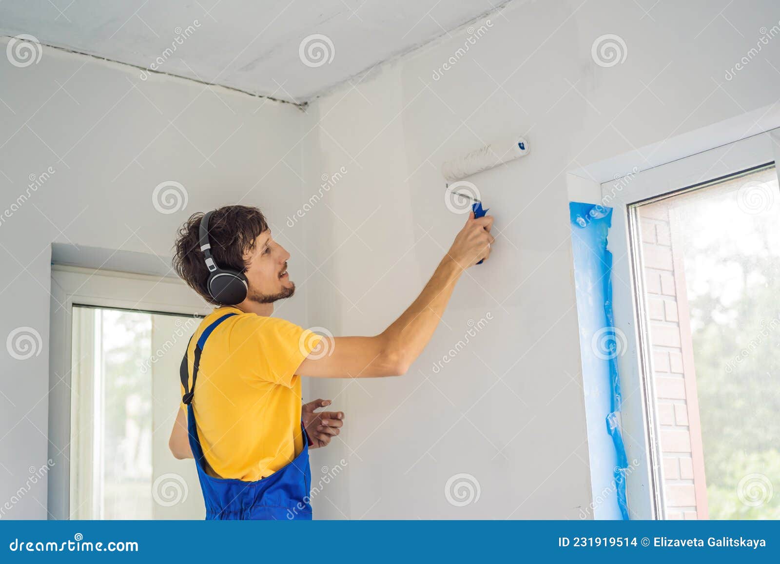 Professional Painter Worker Painting and Priming Wall with Painting