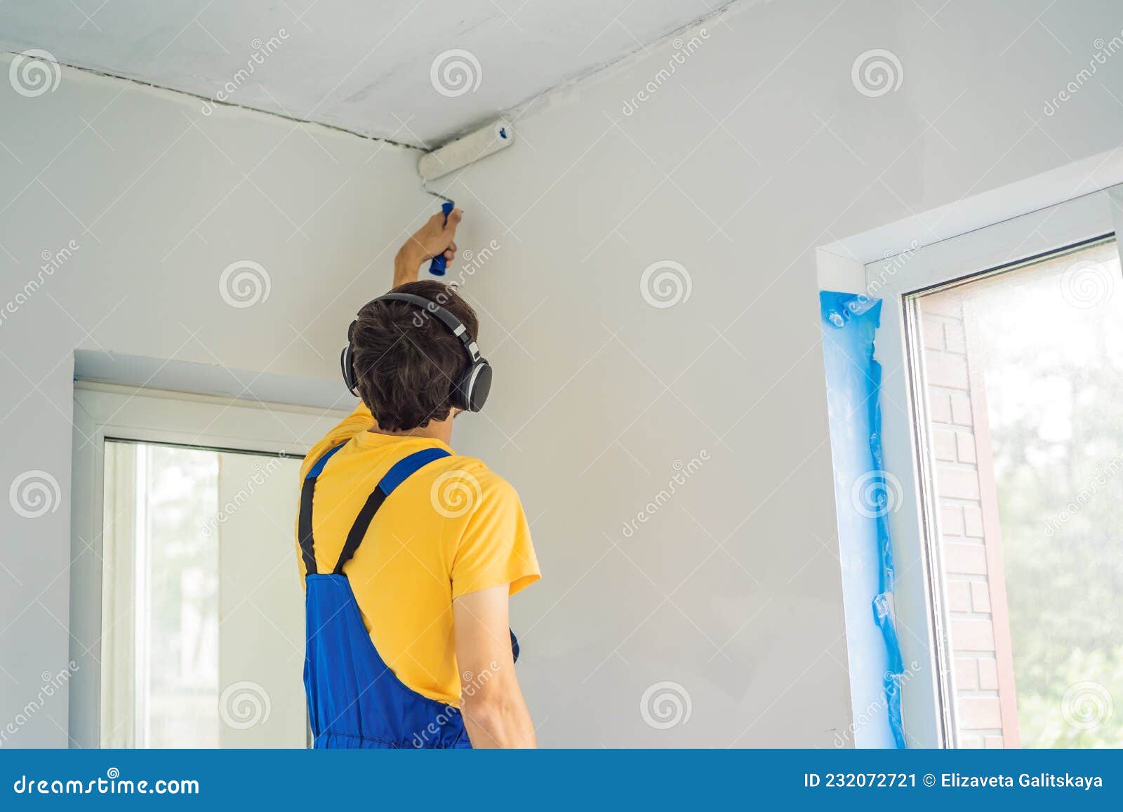 Professional Painter Worker Painting and Priming Wall with Painting