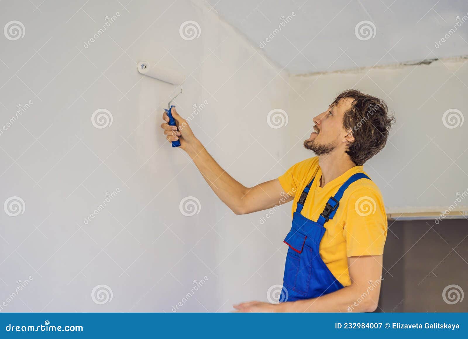 Professional Painter Worker Painting and Priming Wall with Painting