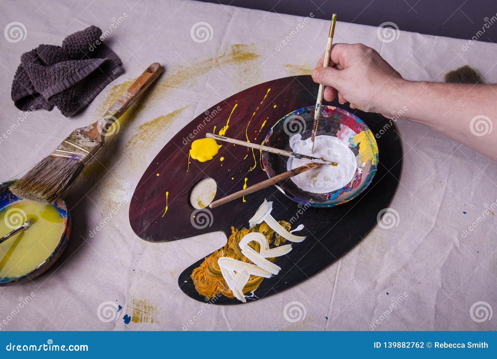 Artist Workplace Hand Holding Paintbrush Dipping it into Wet Paint