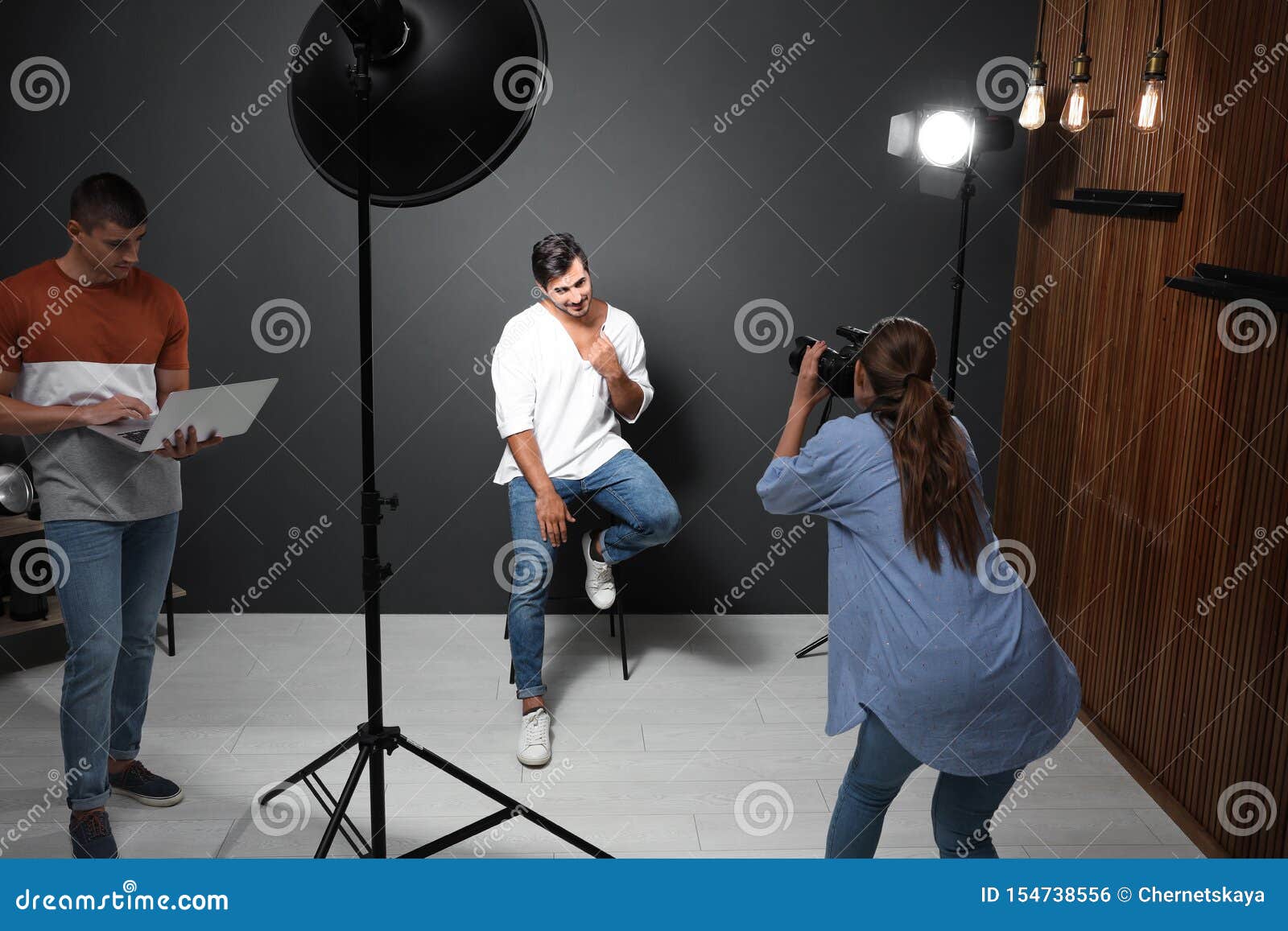 Professional Photographer with Assistant Taking Picture of Young Man in