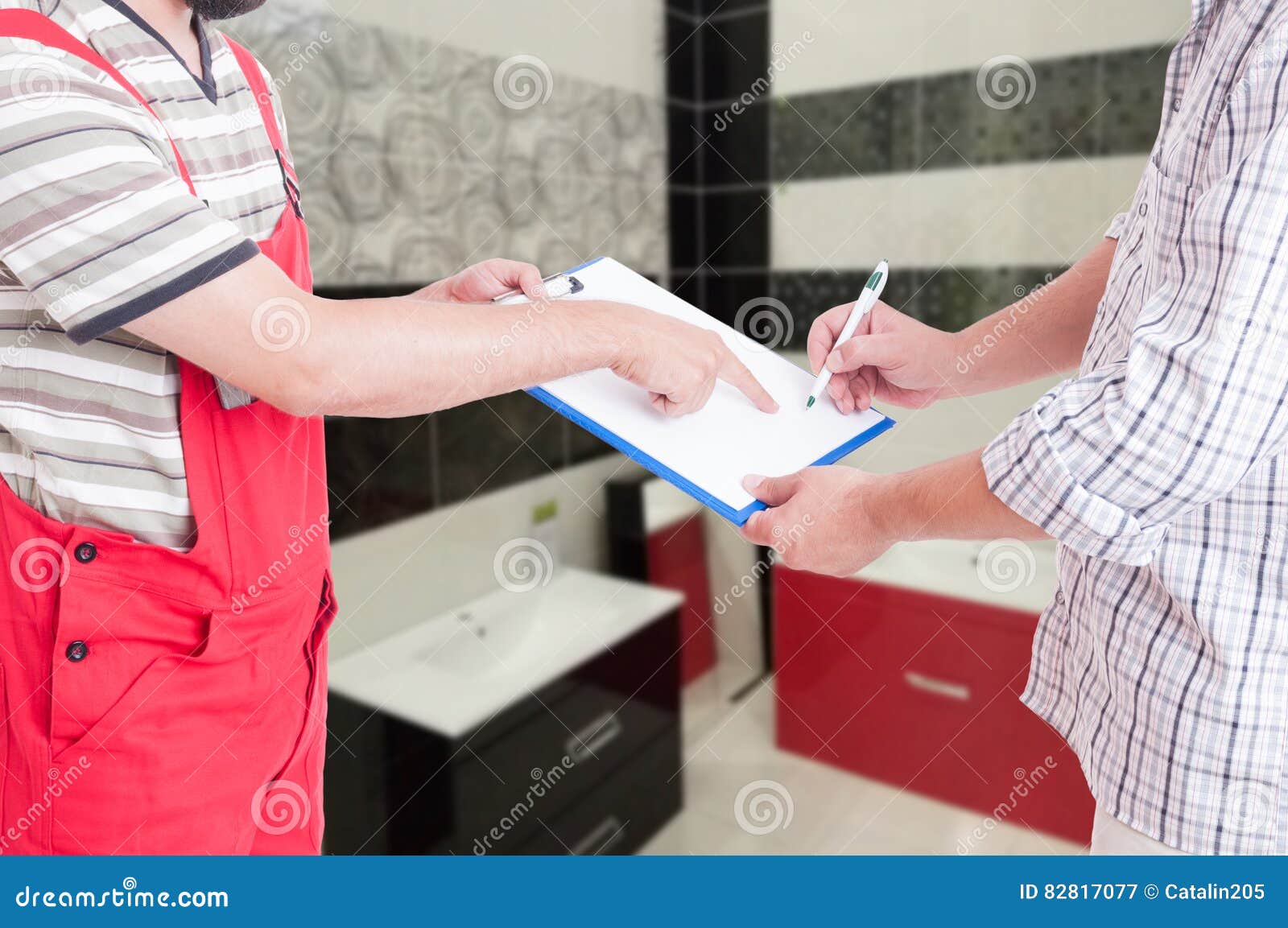 Professional plumber giving his client the contract document for signing after bathroom reparation